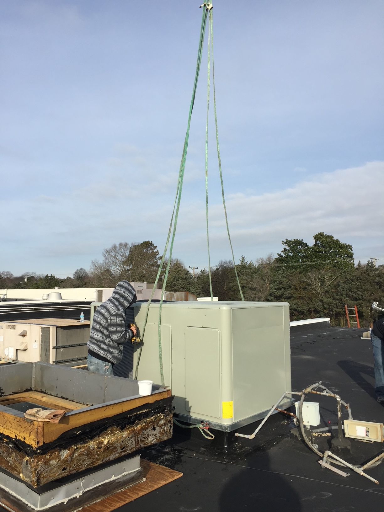 a man is working on a roof with a crane 