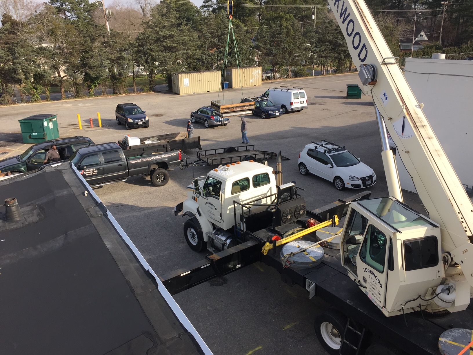 a truck is being towed by a crane in a parking lot 