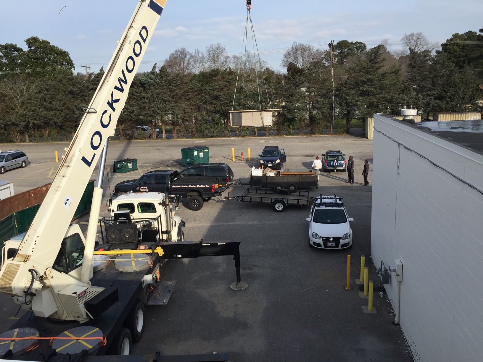 a crane is lifting a car in a parking lot 