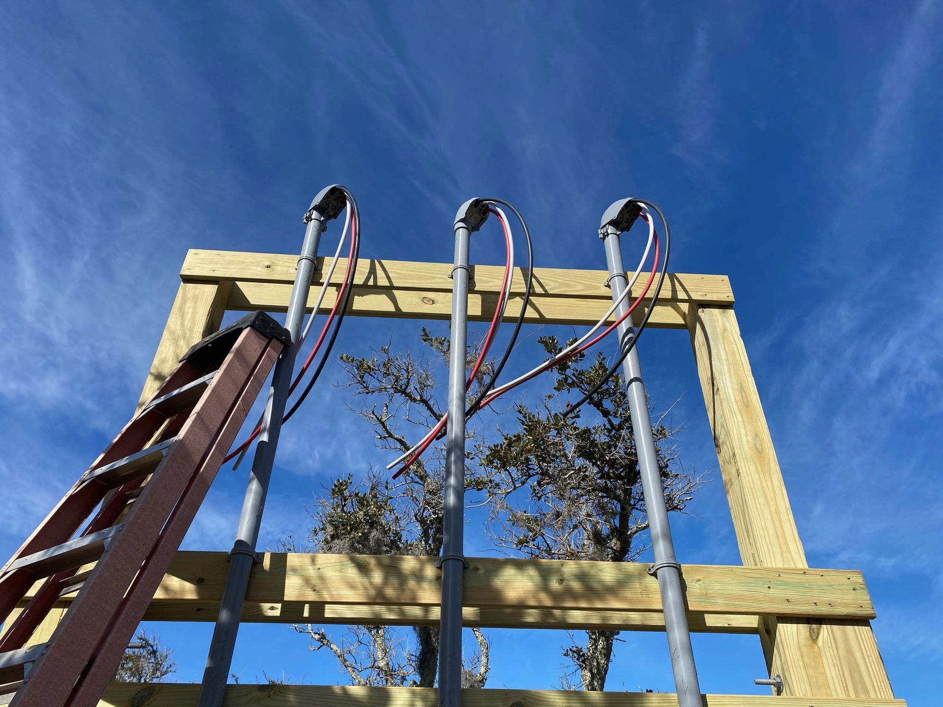 a ladder is sitting on top of a wooden structure with wires attached to it