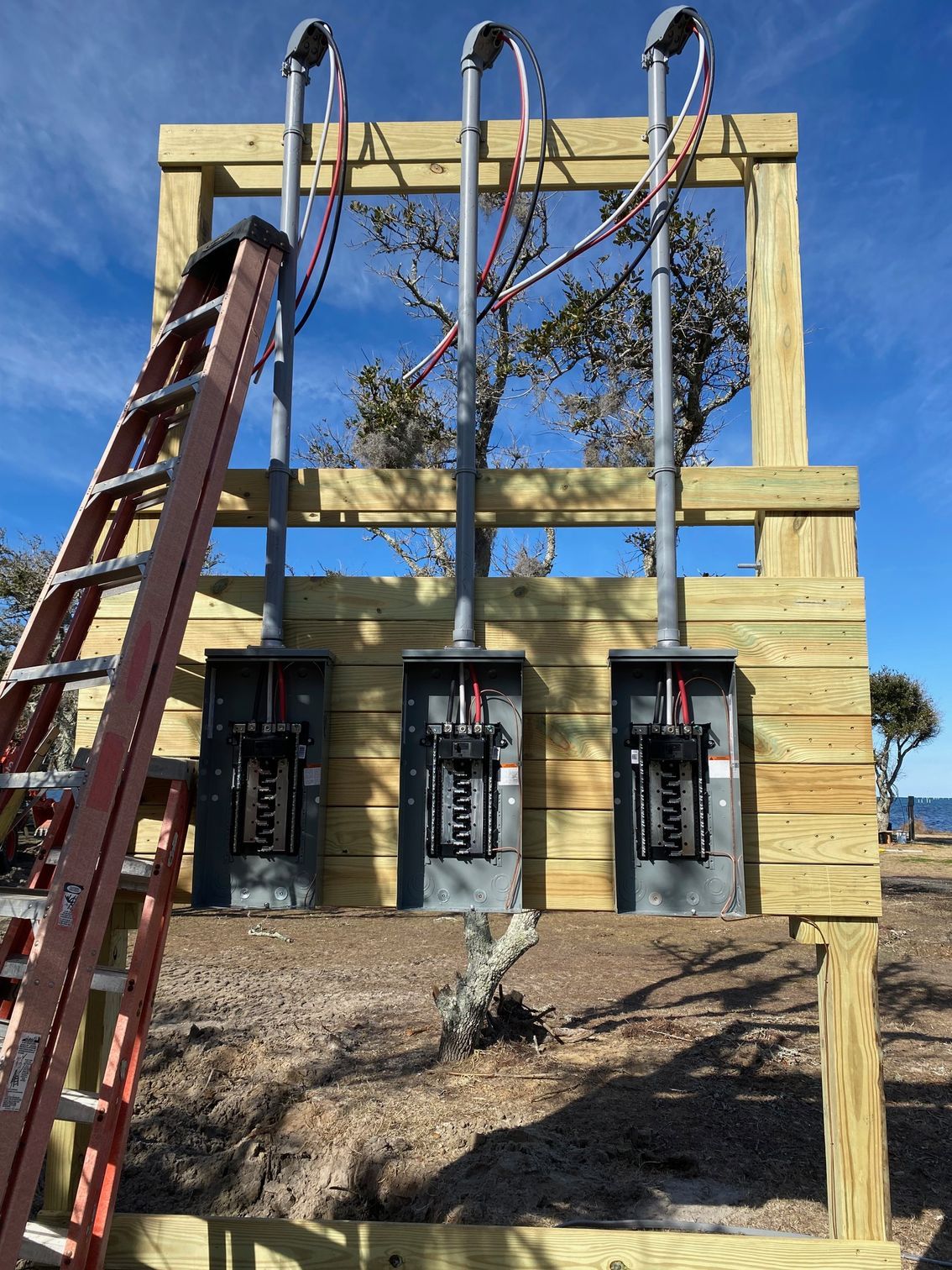 a ladder is sitting on top of a wooden structure with electrical panels on it