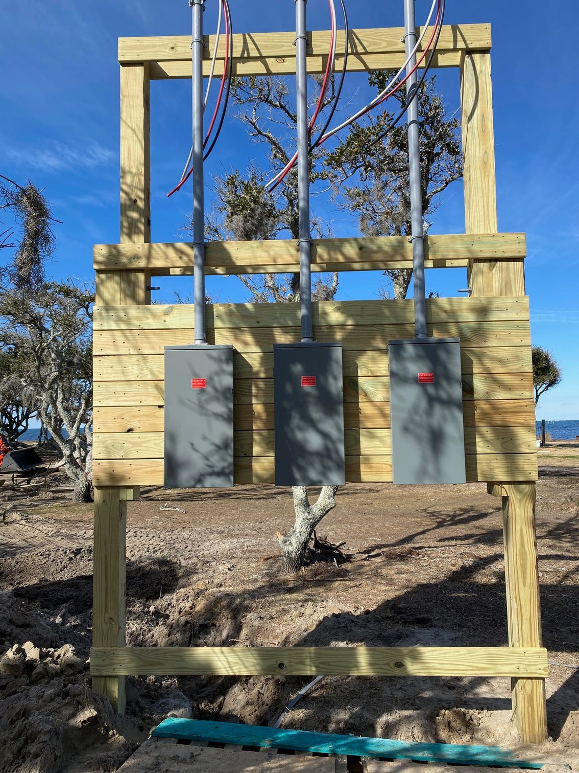 a wooden fence with three electrical boxes attached to it