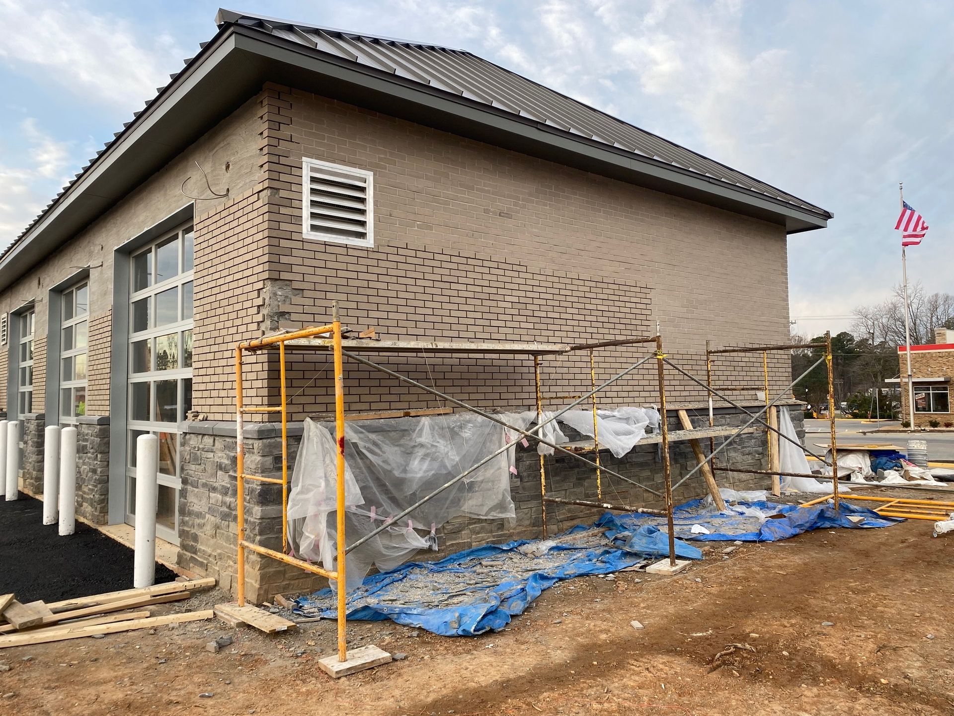 a building under construction with scaffolding around it and a flag in the background