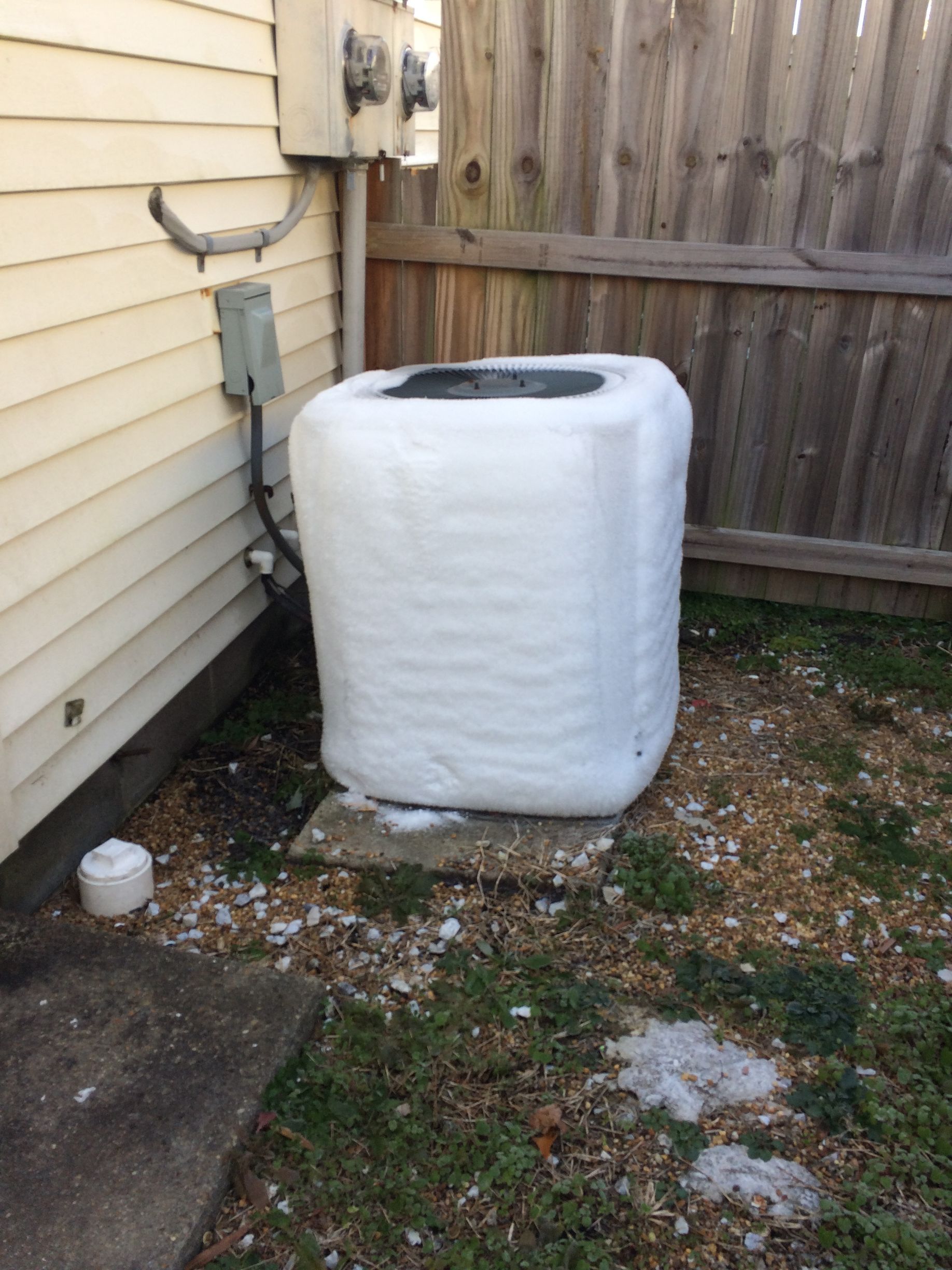 an air conditioner is wrapped in plastic and sitting outside of a house 