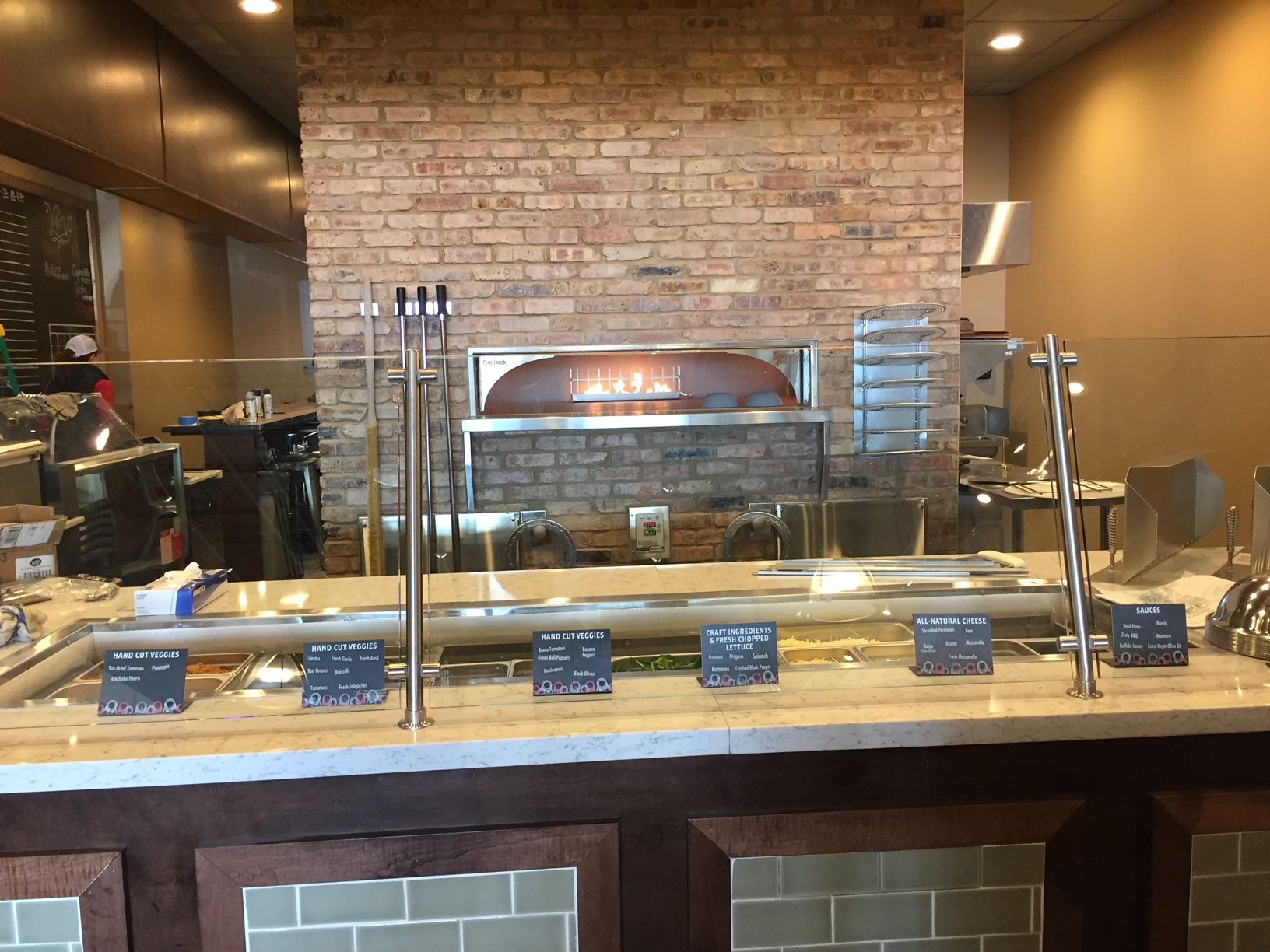 a restaurant with a brick wall and a pizza oven