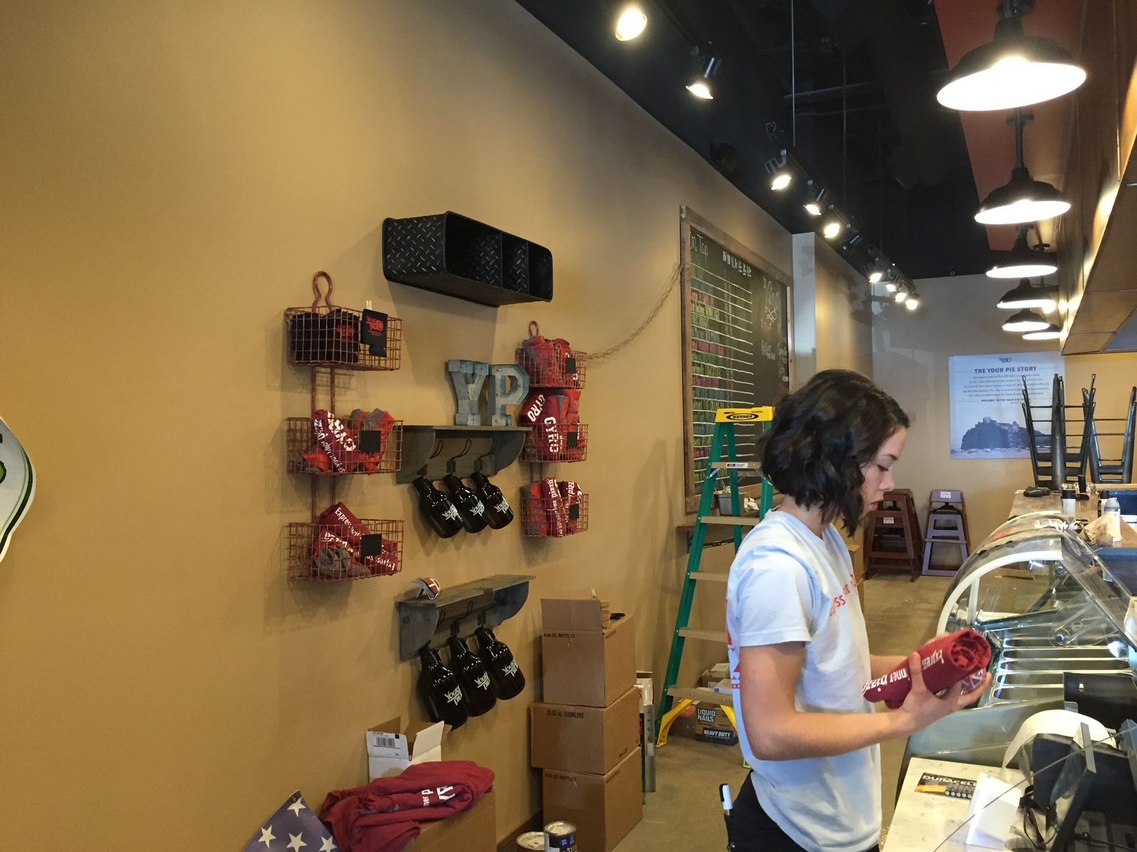 a woman is standing in front of a counter in a restaurant 