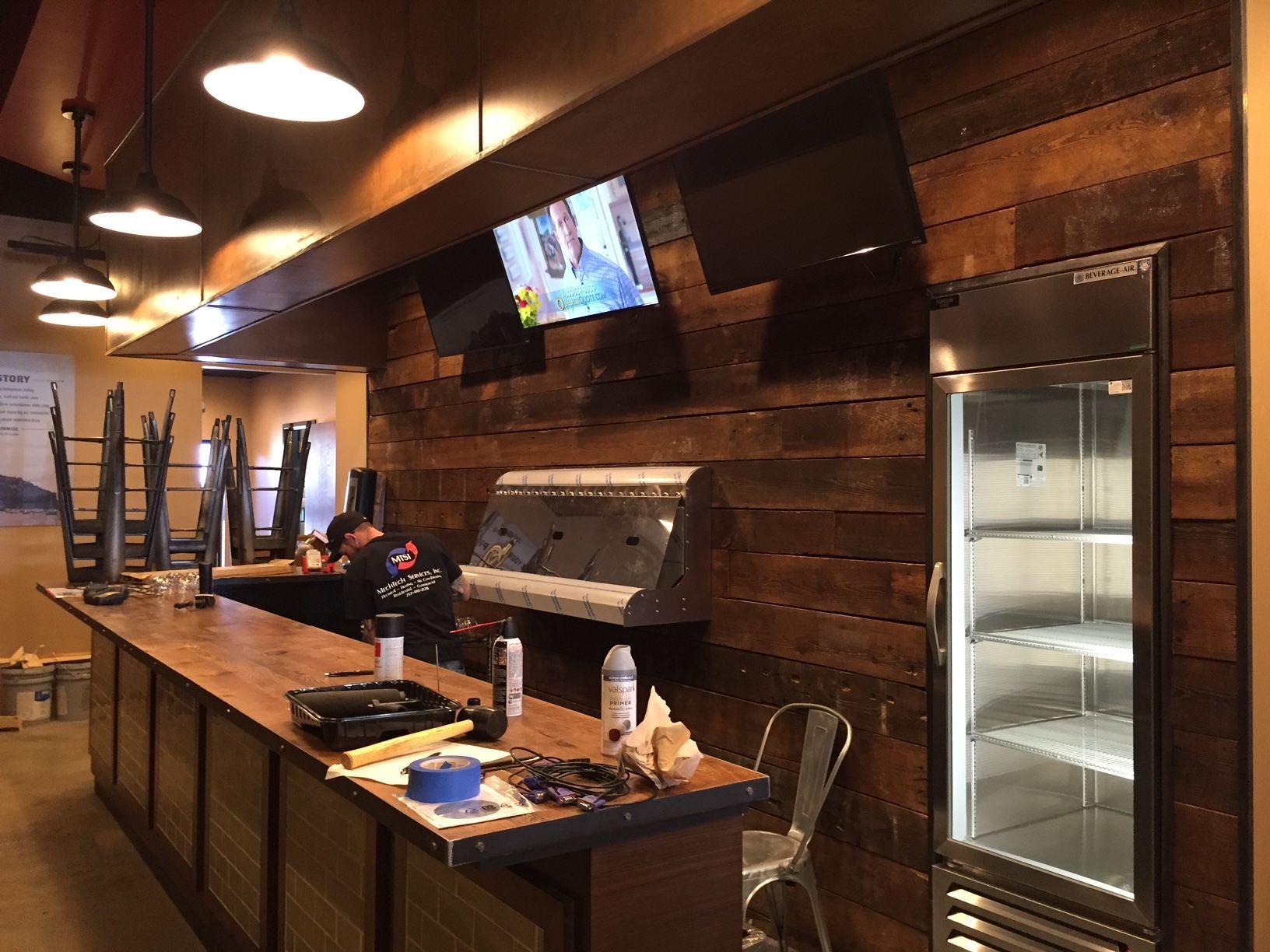 a restaurant with a long counter and a refrigerator 