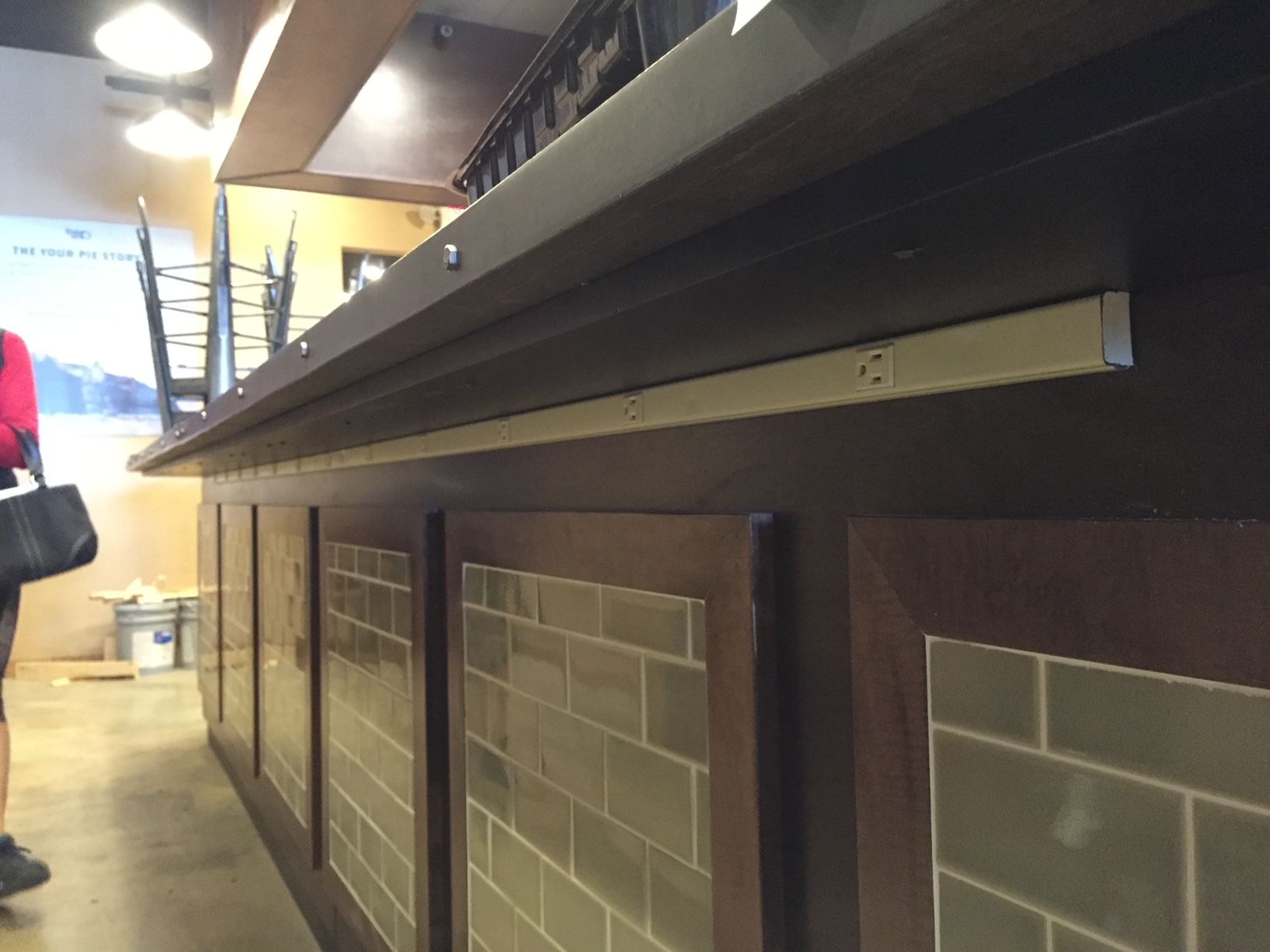 a woman is standing in front of a counter in a restaurant
