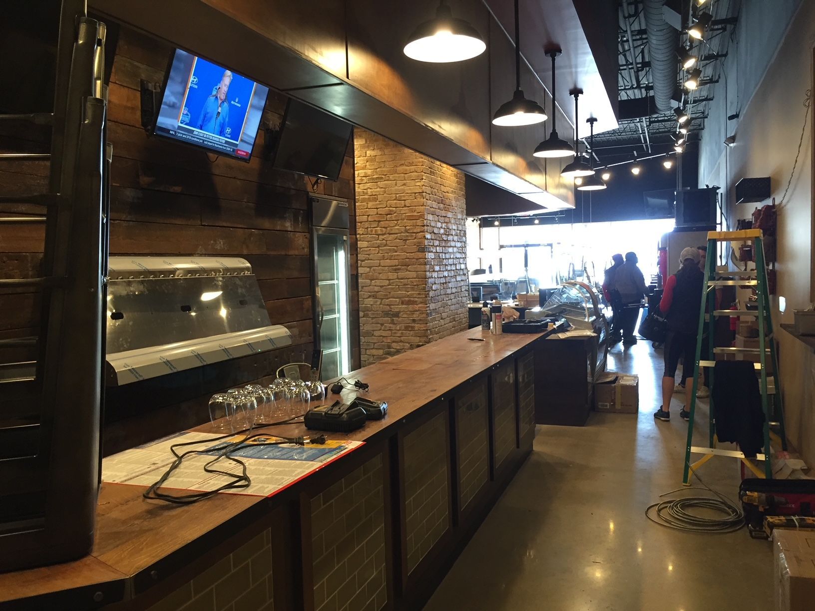 a restaurant with a long bar and a television on the wall