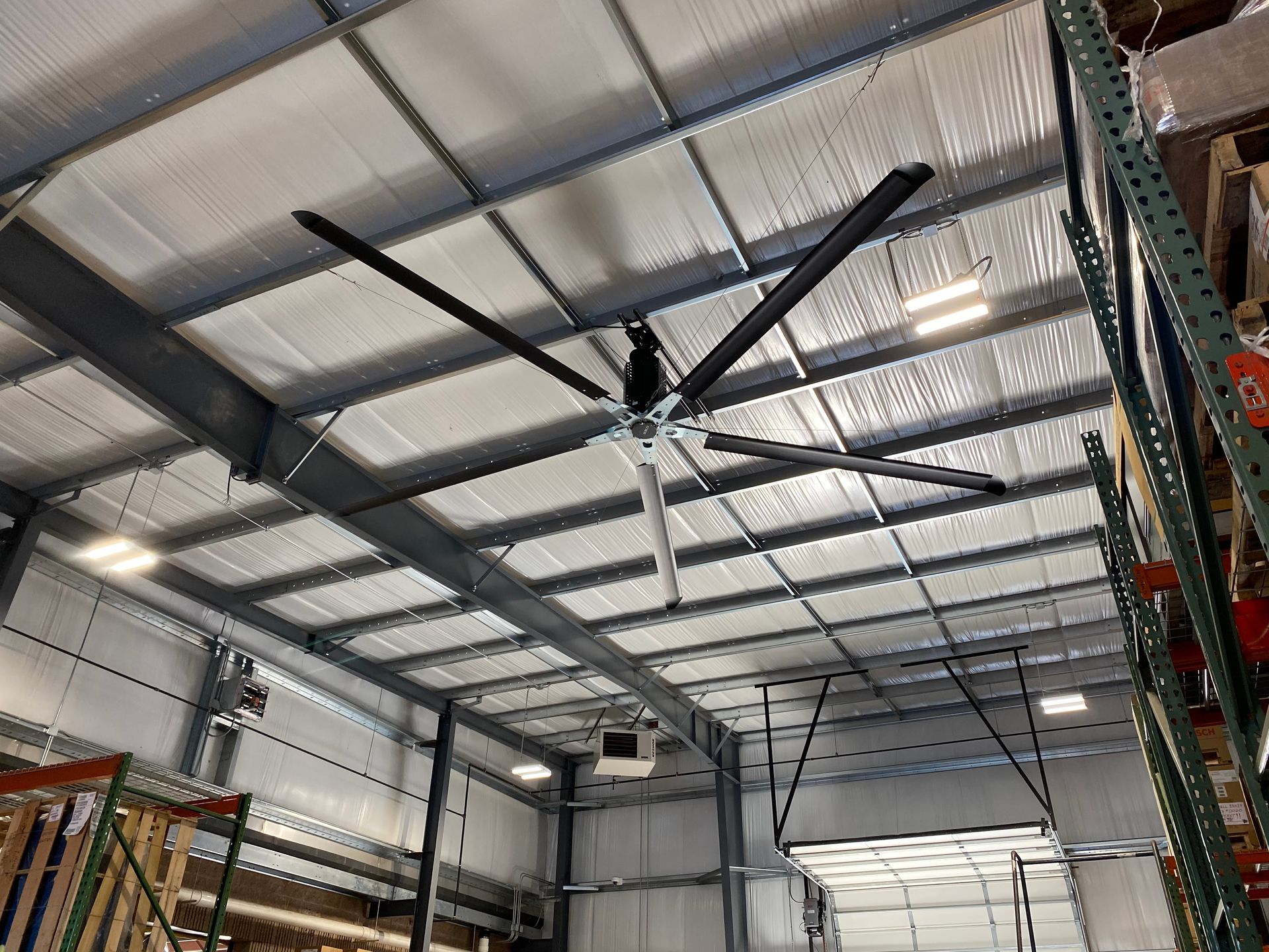 a large ceiling fan is hanging from the ceiling of a warehouse