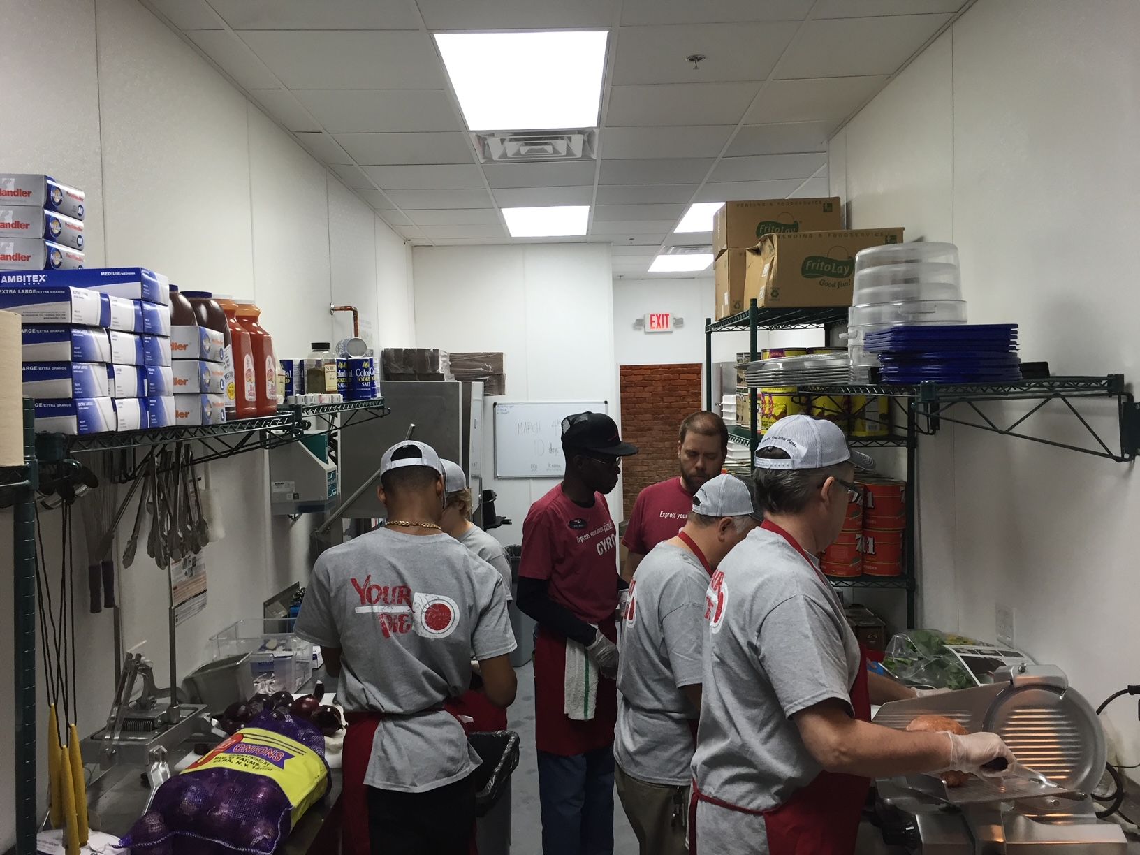 a group of people are standing in a kitchen preparing food 