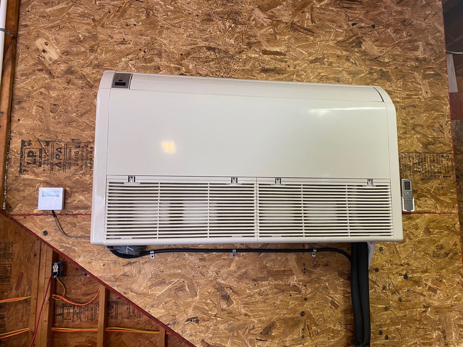 a white air conditioner is hanging on a wooden wall