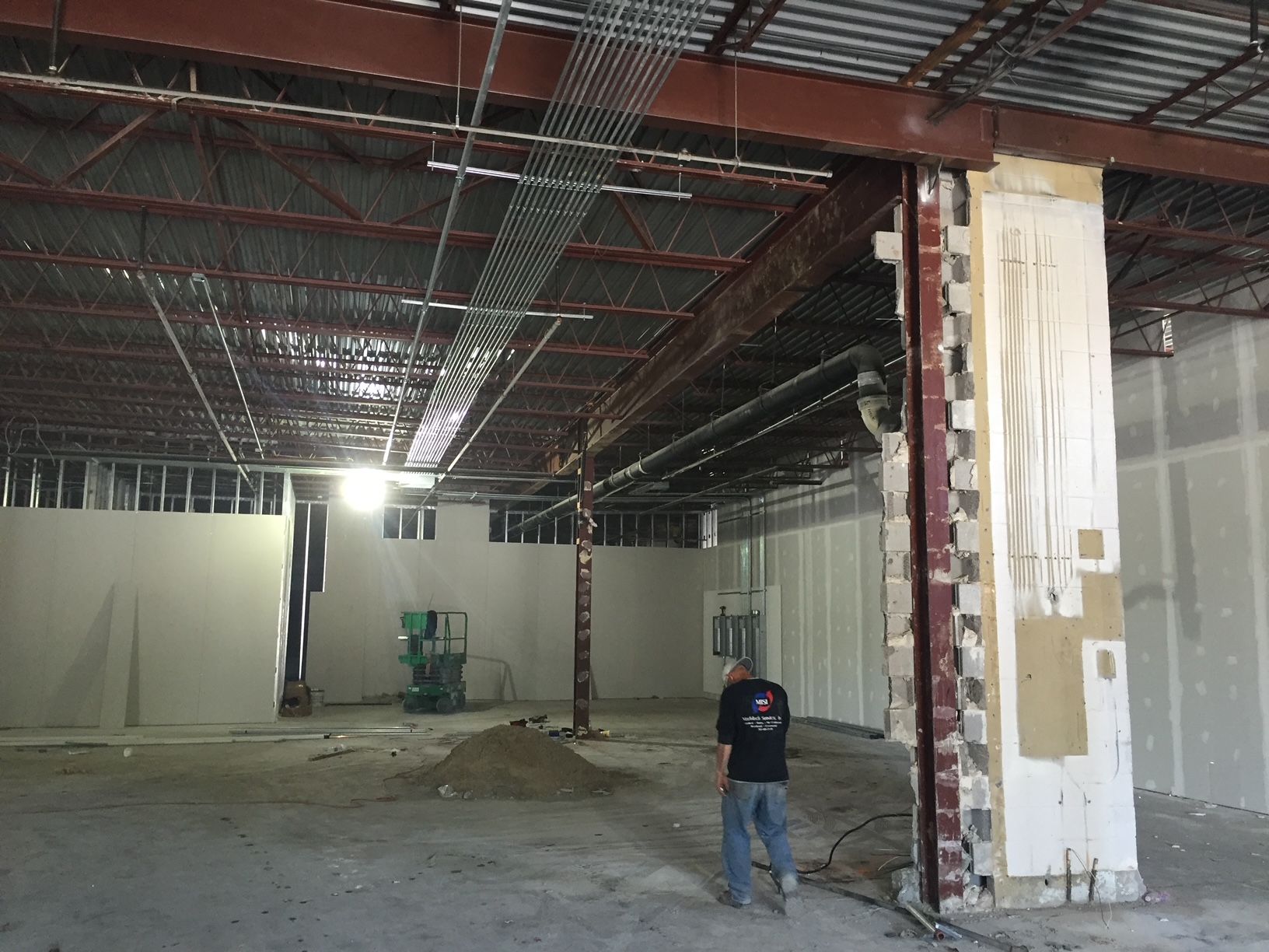 a man in a black shirt is standing in an empty building