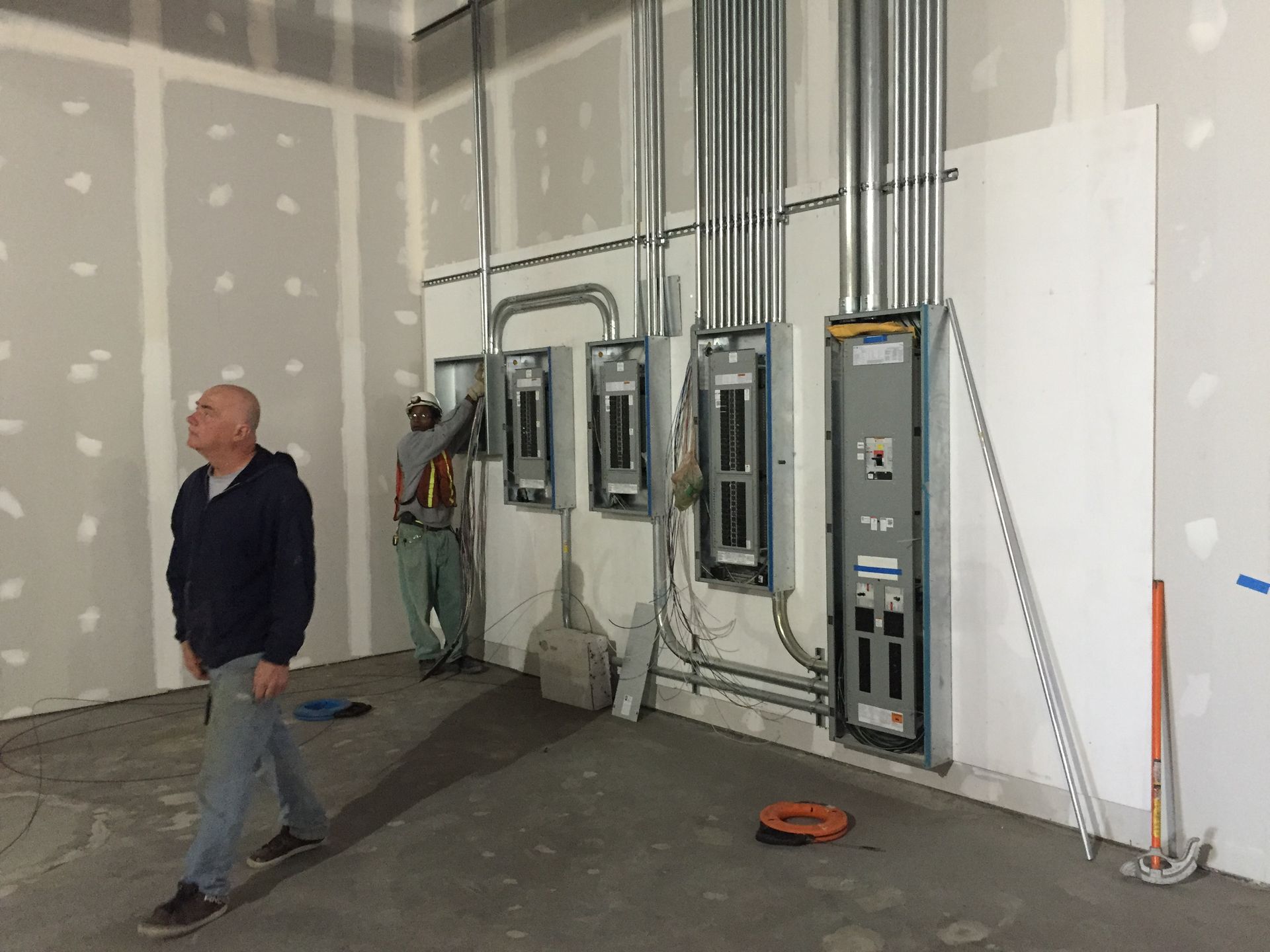 a man is walking through a room with electrical panels on the wall 