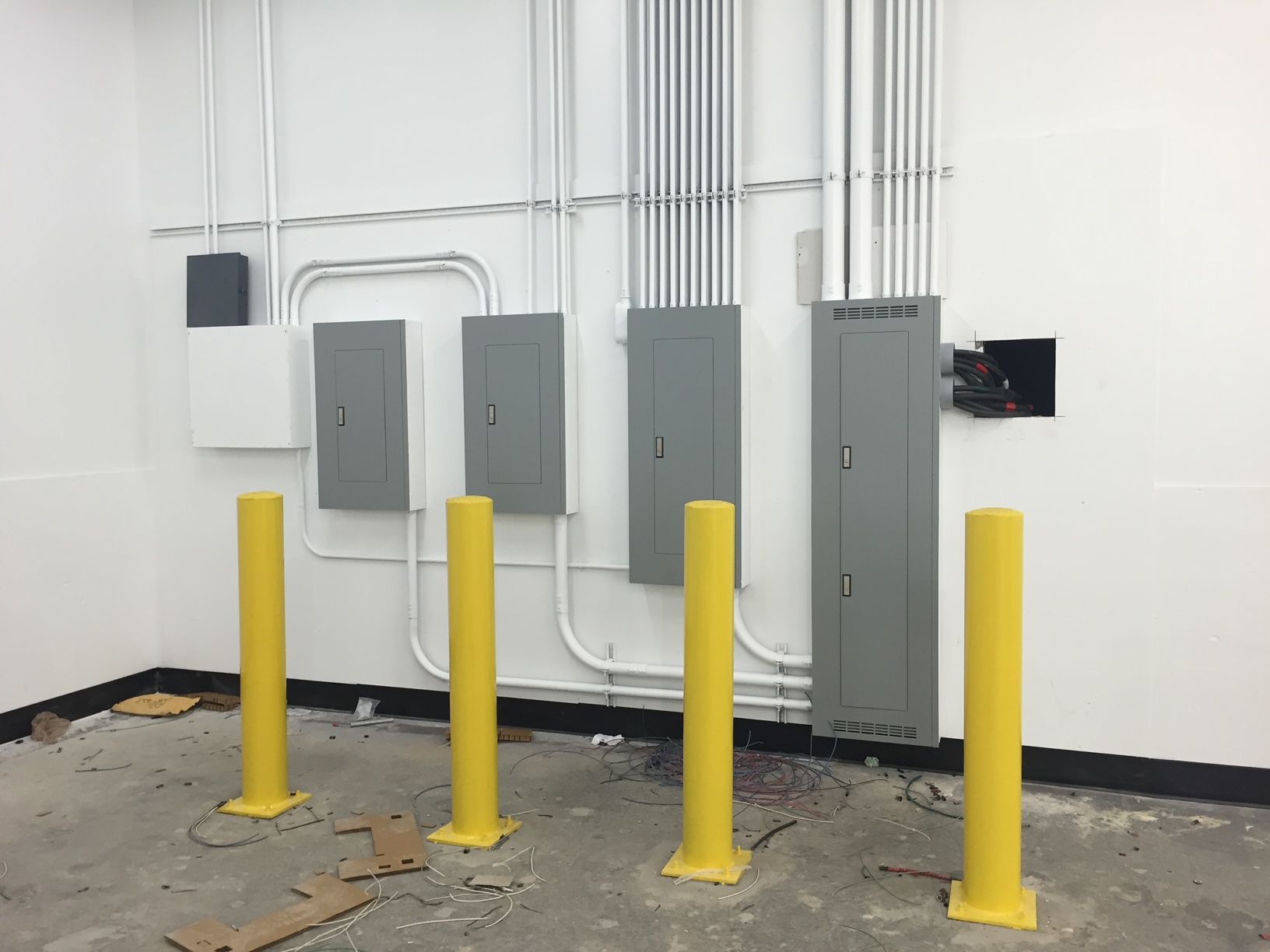 a room with yellow poles and electrical panels on the wall 