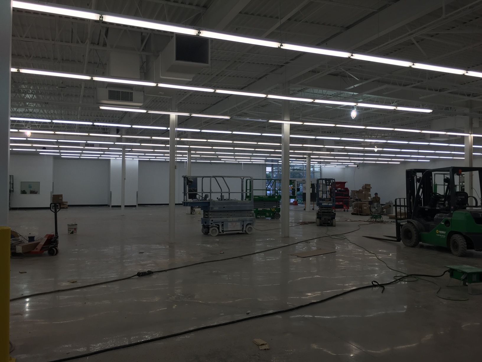 an empty warehouse with a forklift in the middle of it