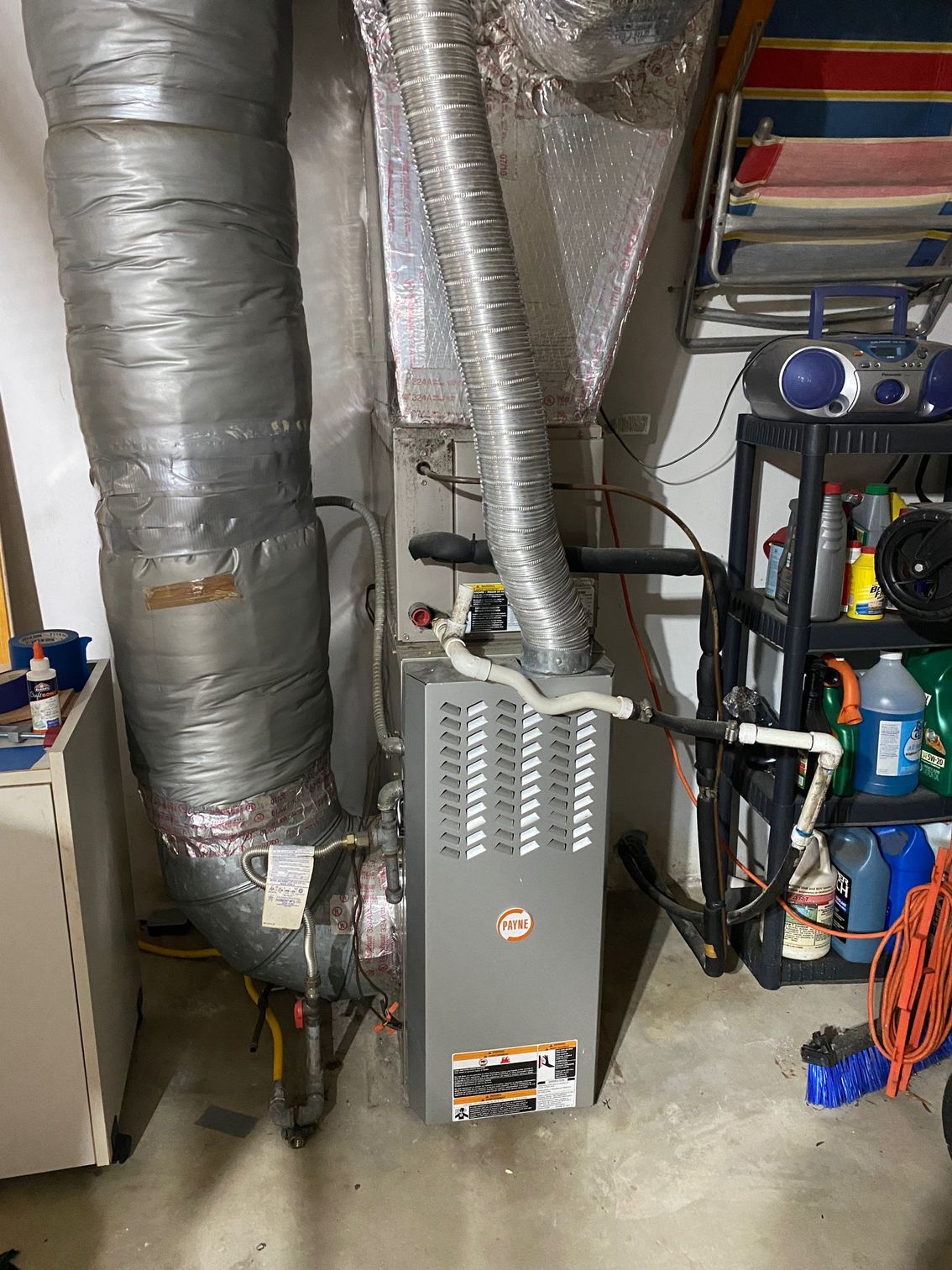 a furnace is sitting in a basement next to a hose