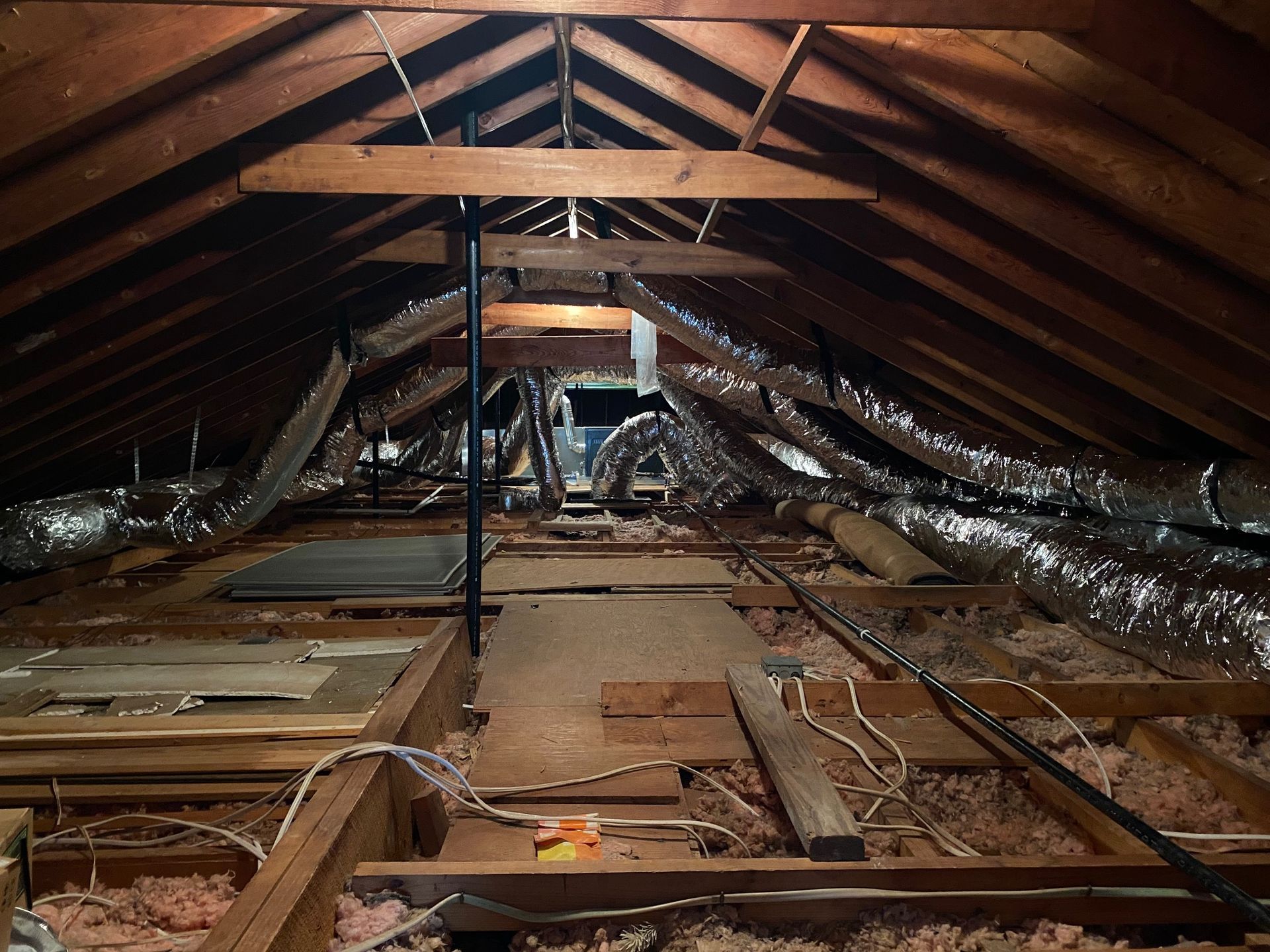an attic with a lot of wooden beams and ducts