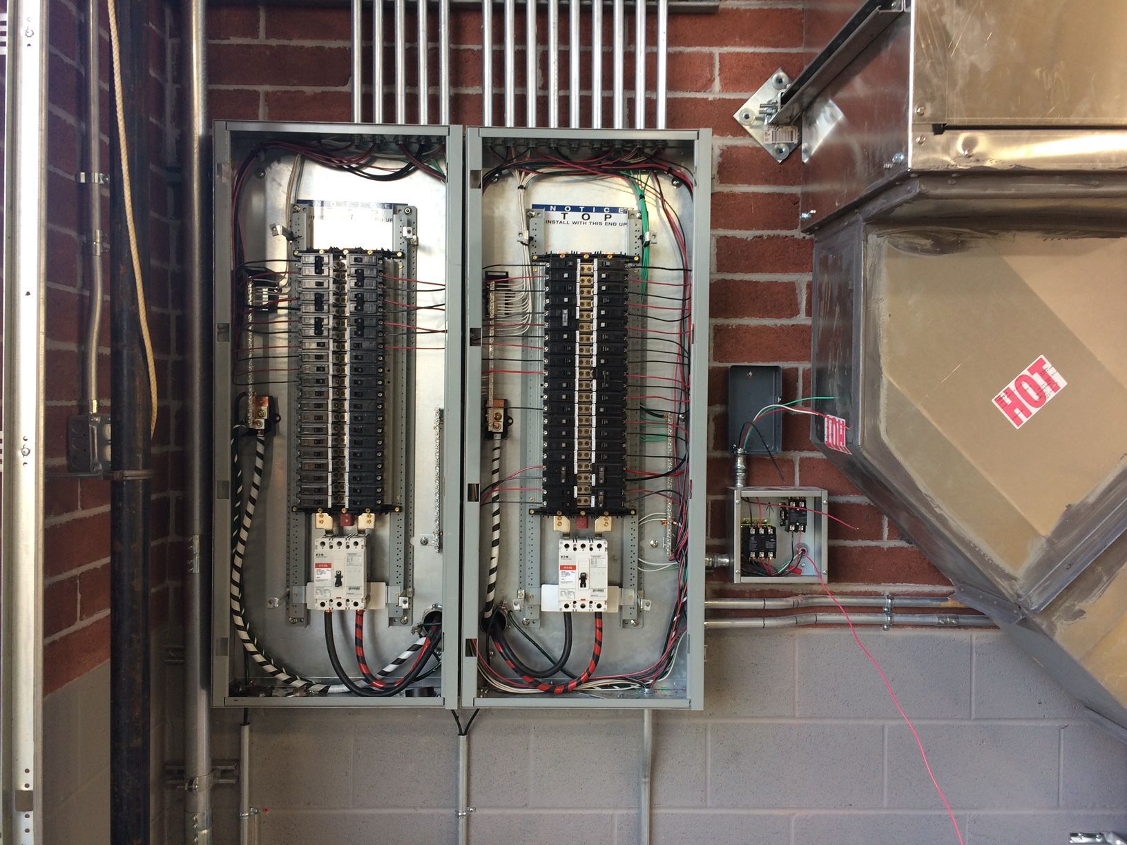 two electrical boxes are sitting on a brick wall 