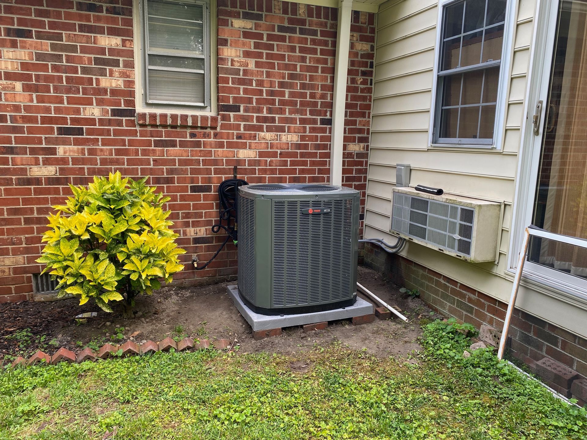 an air conditioner is sitting on the side of a brick house
