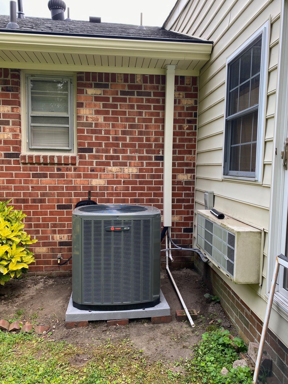 an air conditioner is sitting on the side of a brick house