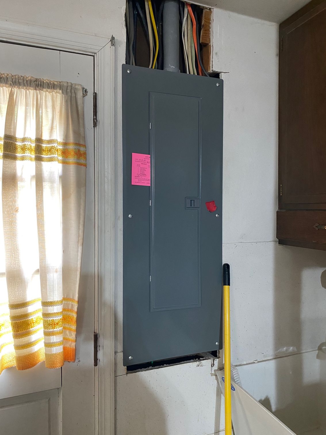 a gray electrical box next to a window