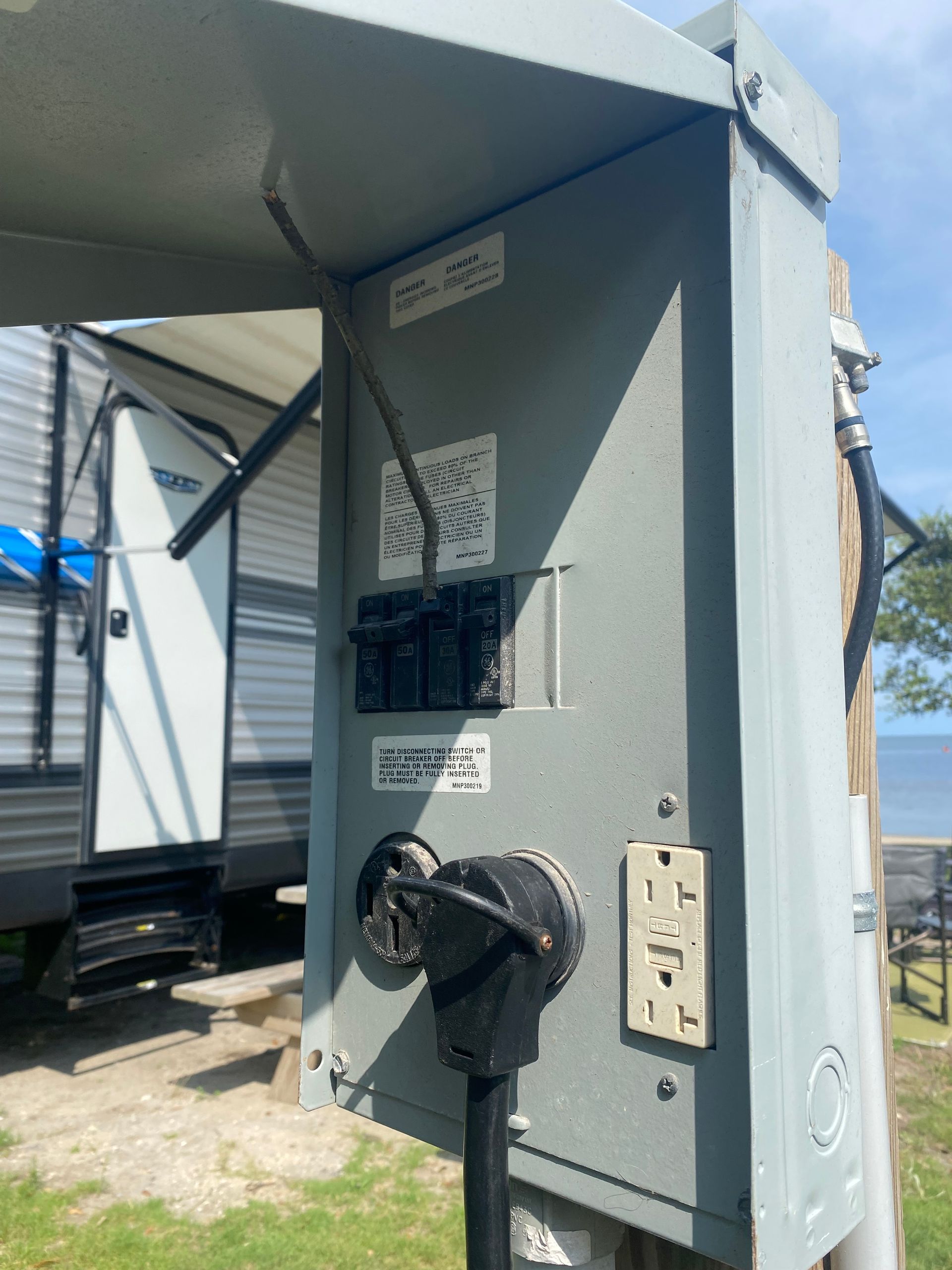 a rv is parked in the grass next to a power box