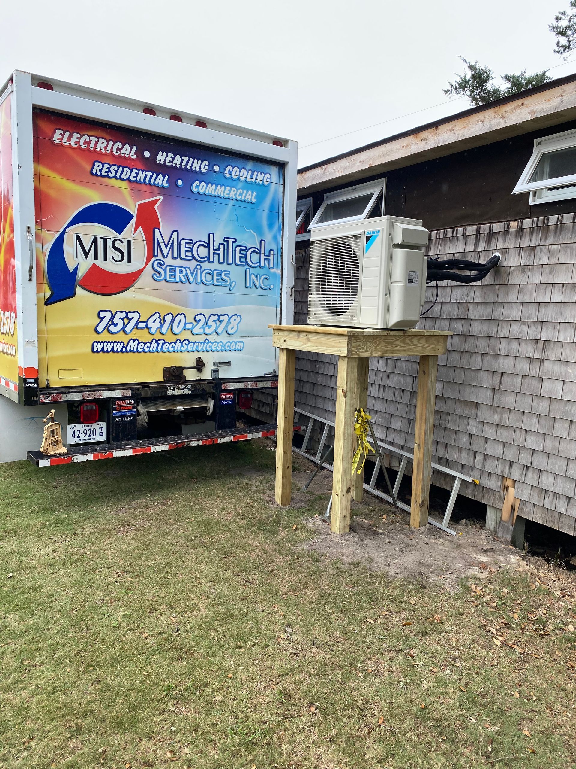 a truck with an air conditioner on the back of it is parked in front of a brick building