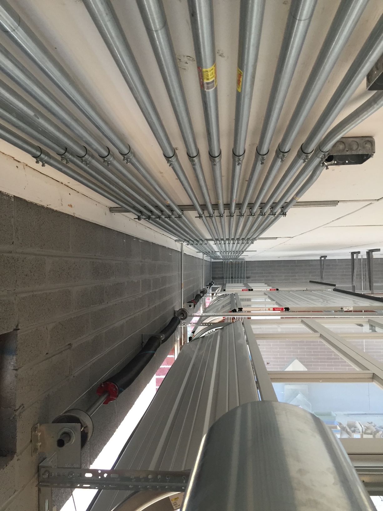 a bunch of pipes are hanging from the ceiling of a building