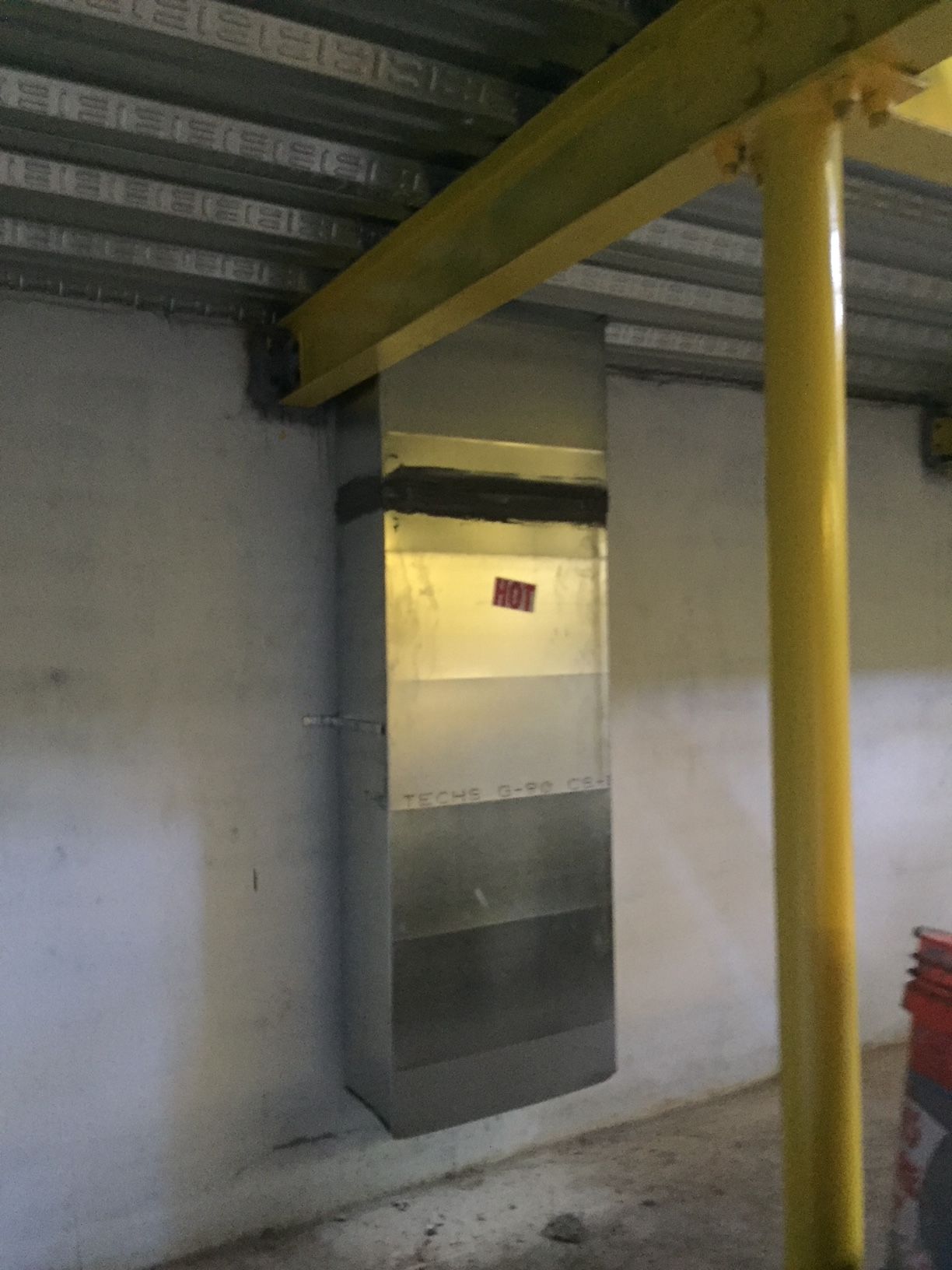 a stainless steel duct is hanging from the ceiling of a building
