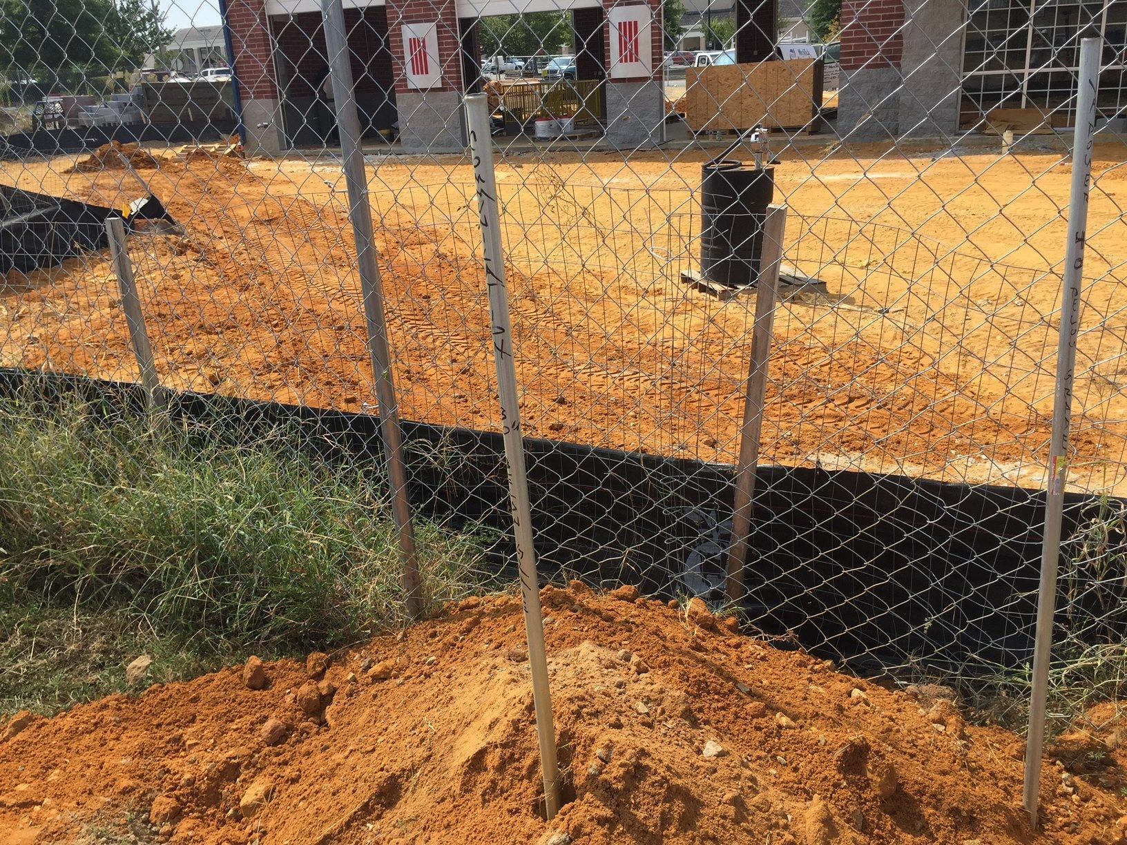 a chain link fence is surrounded by dirt and grass 