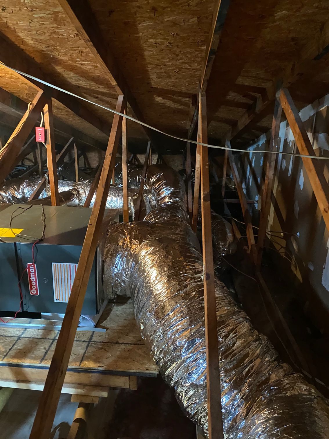 a large duct is hanging from the ceiling of an attic
