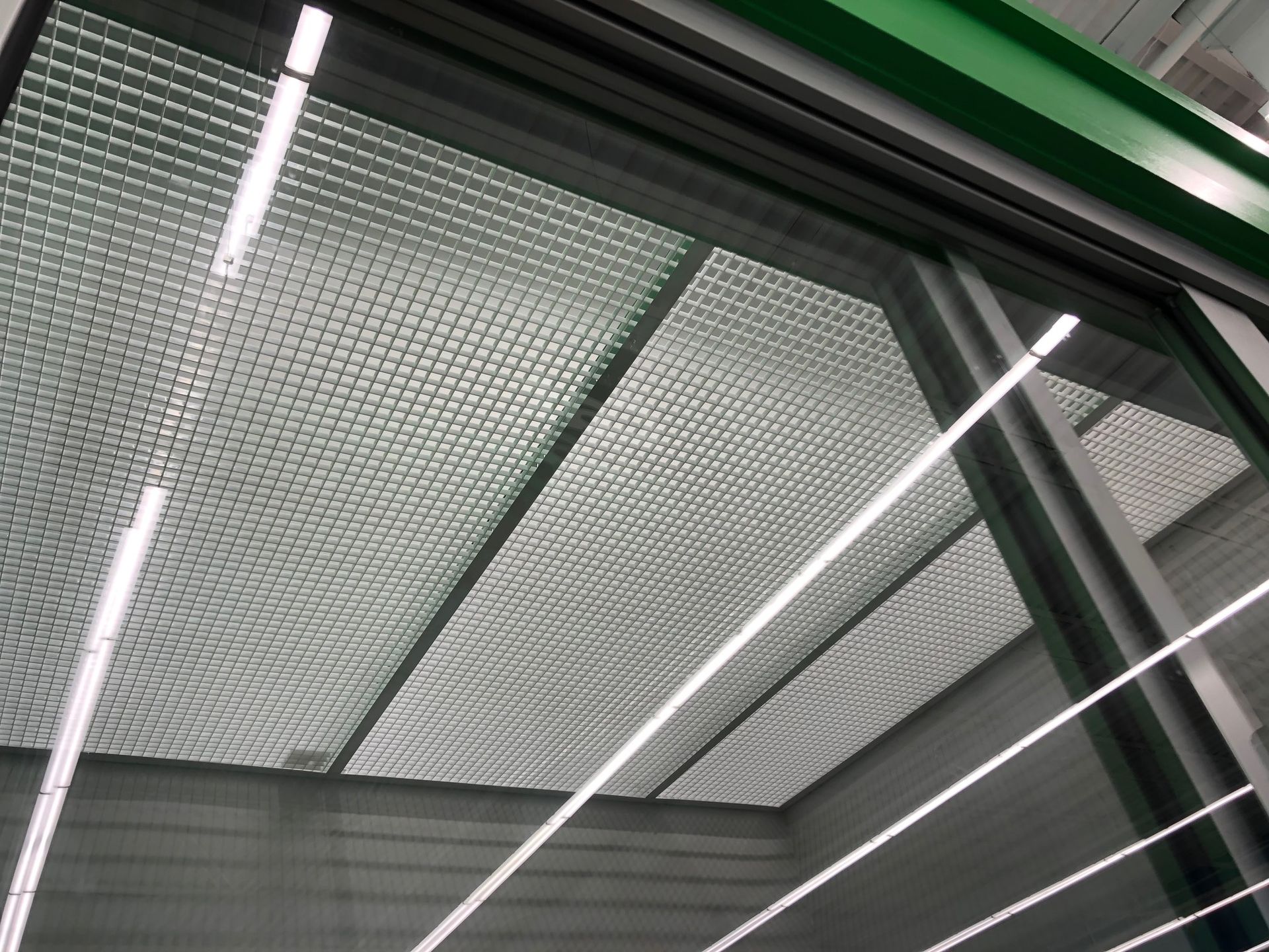 a ceiling with a grid pattern and lights hanging from it