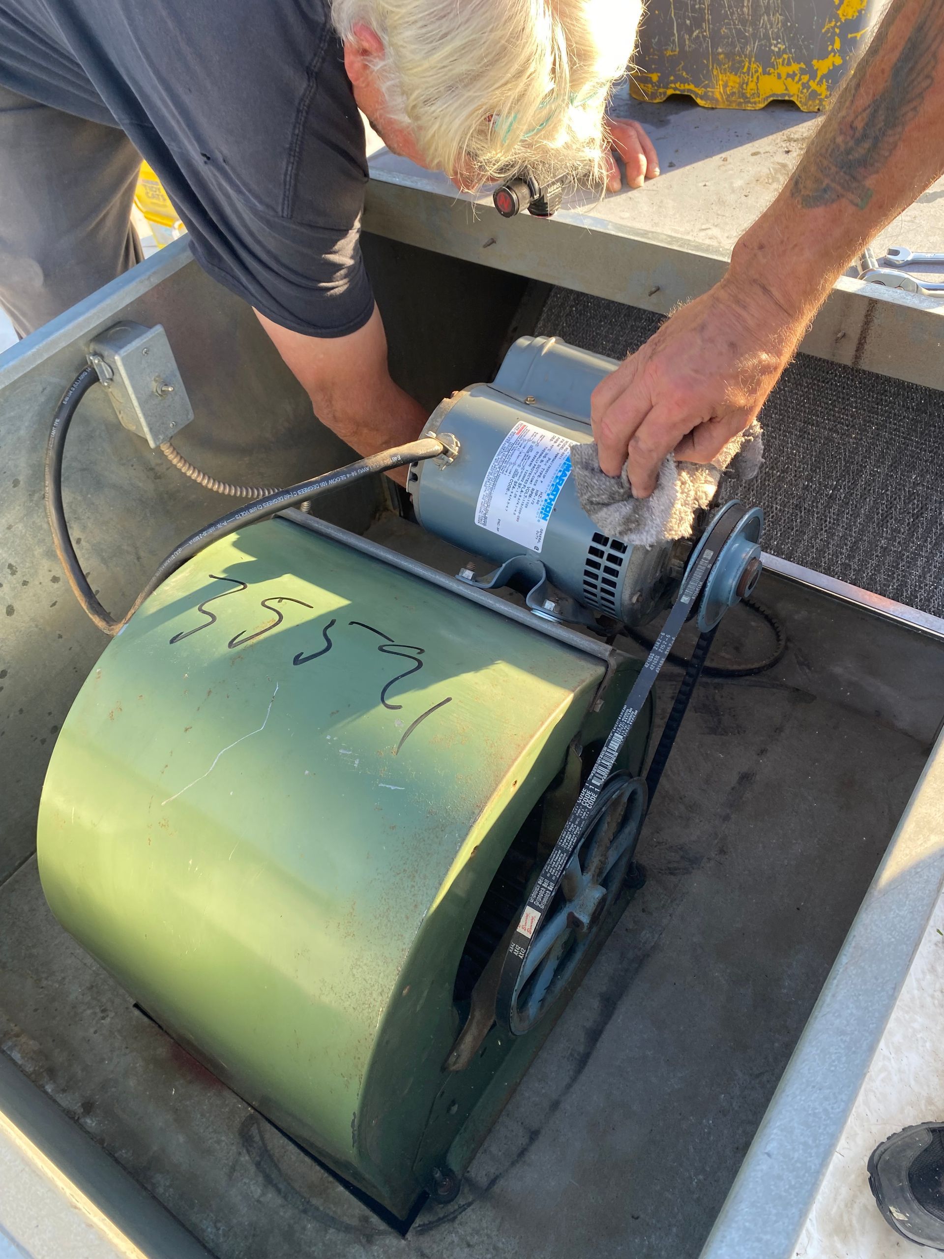 a man is working on a fan with a motor attached to it