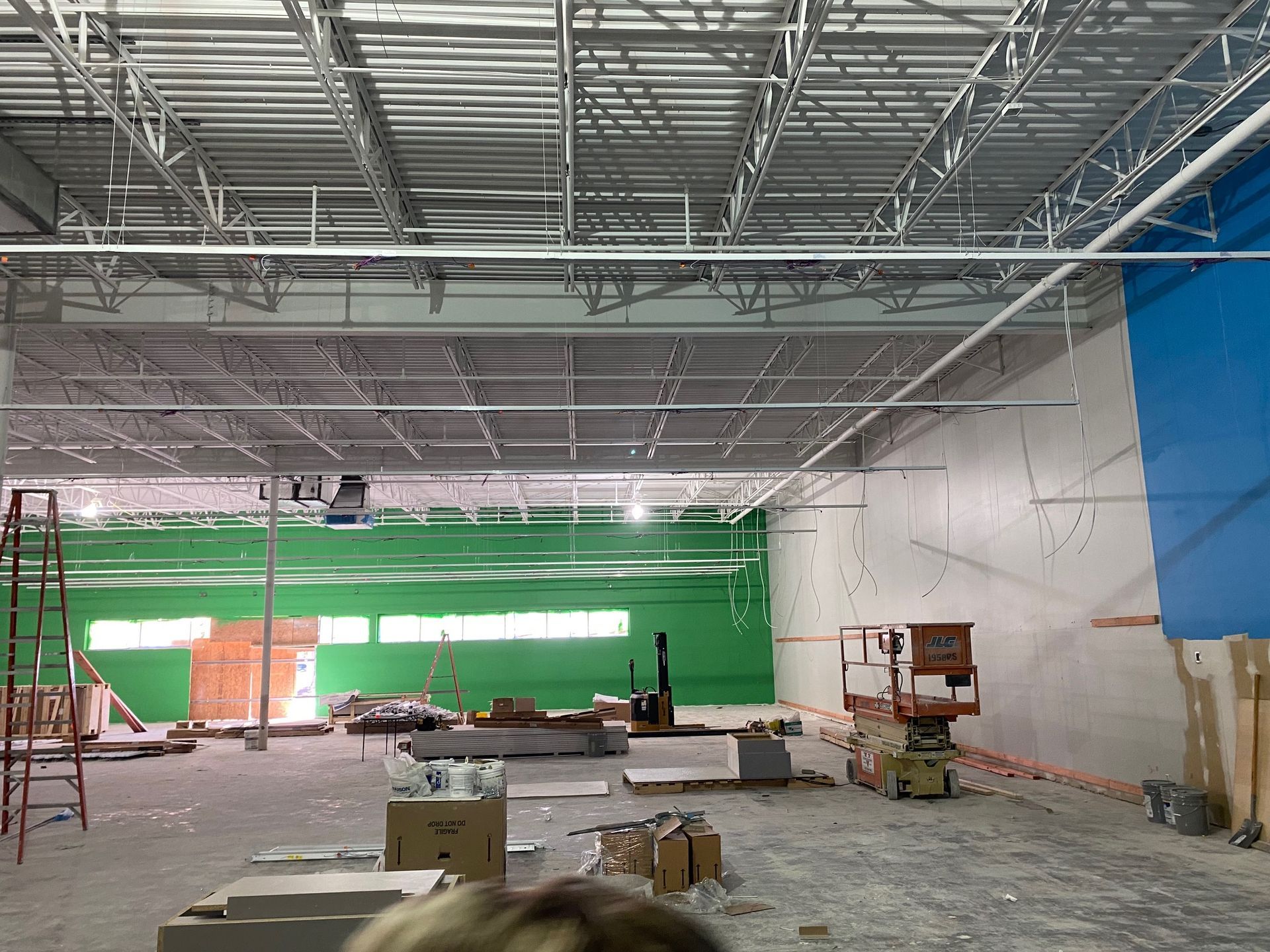 the inside of a building under construction with a green wall