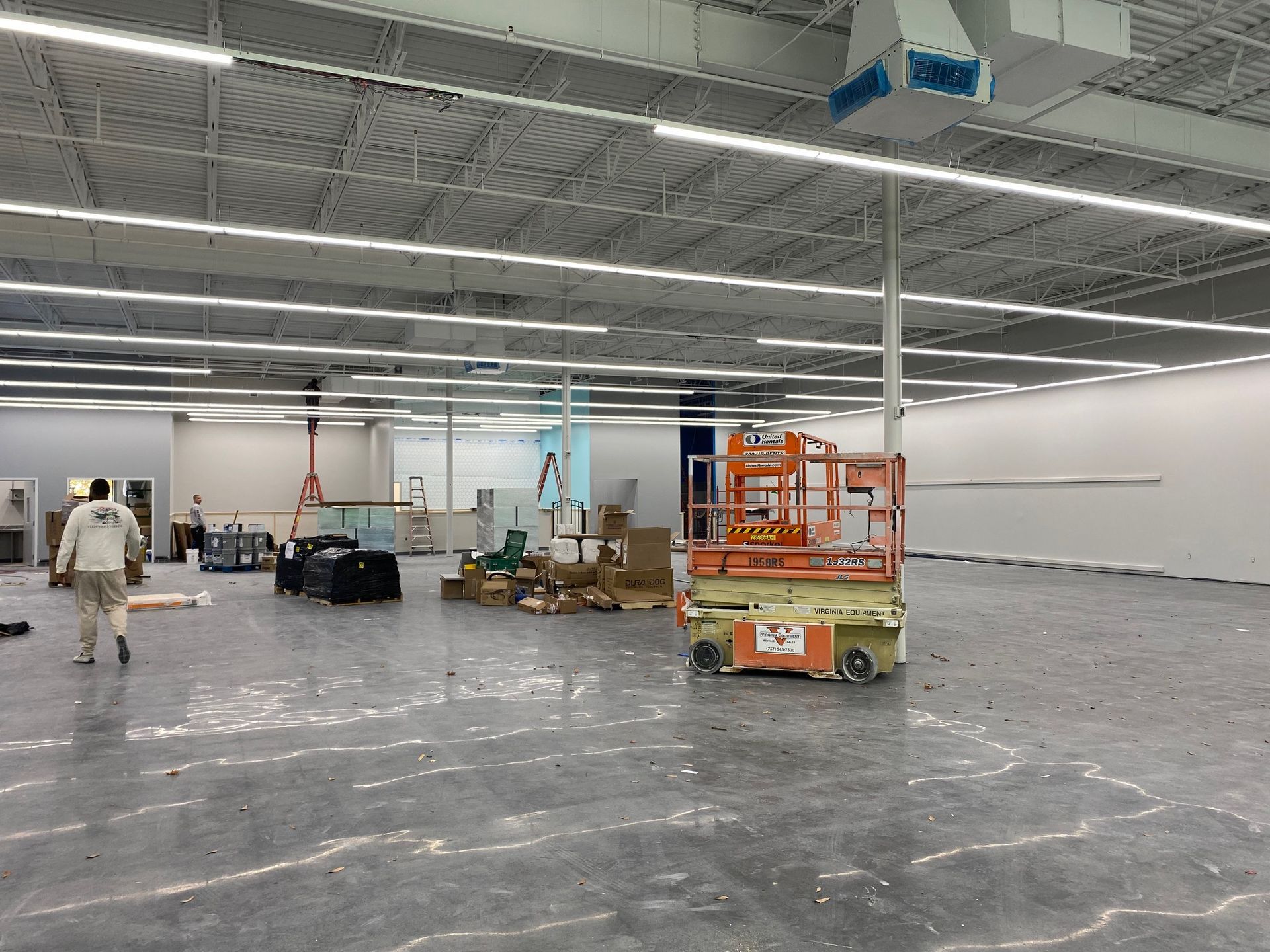 a large empty warehouse with a man walking through it