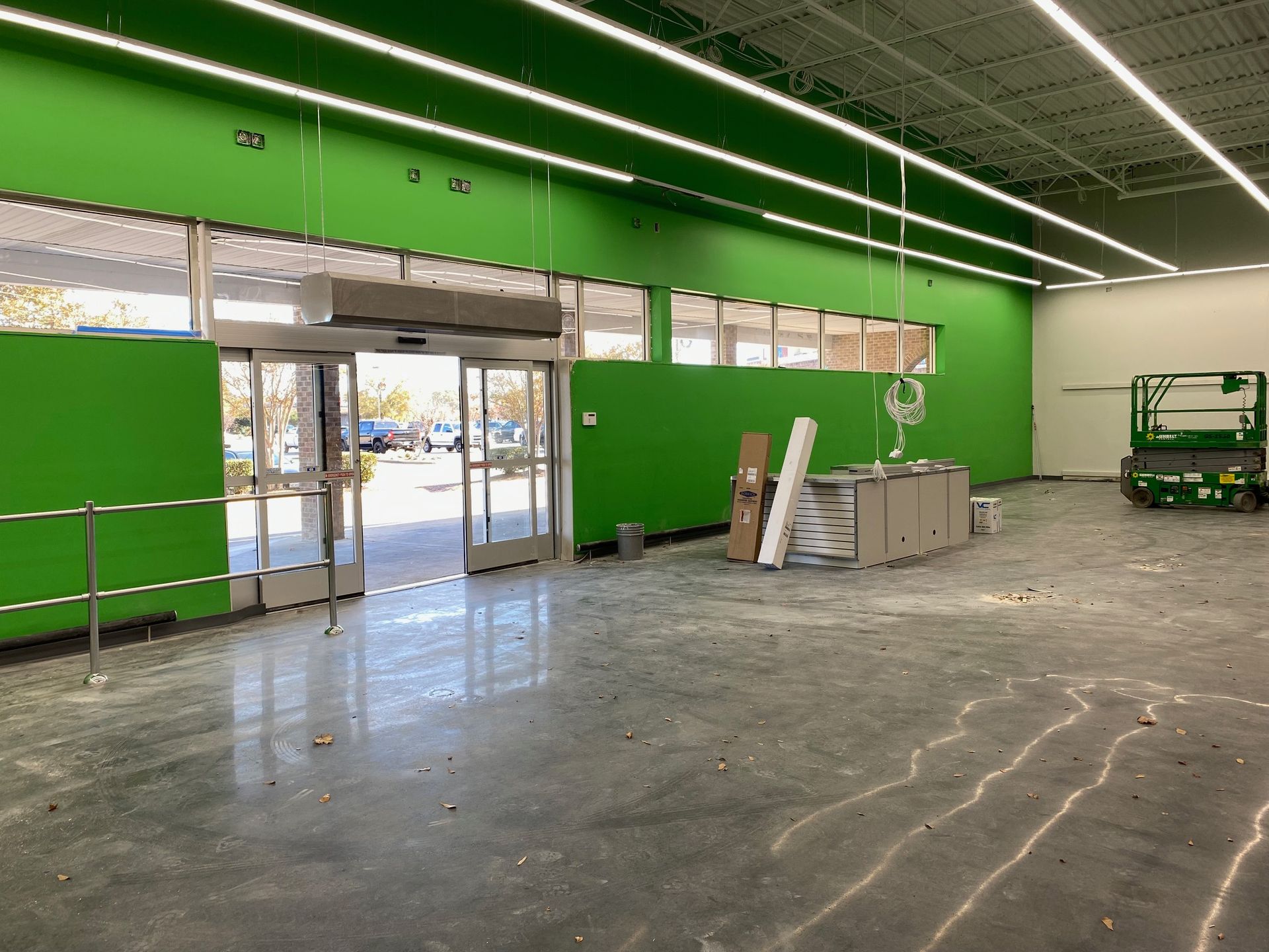 an empty store with green walls and a concrete floor