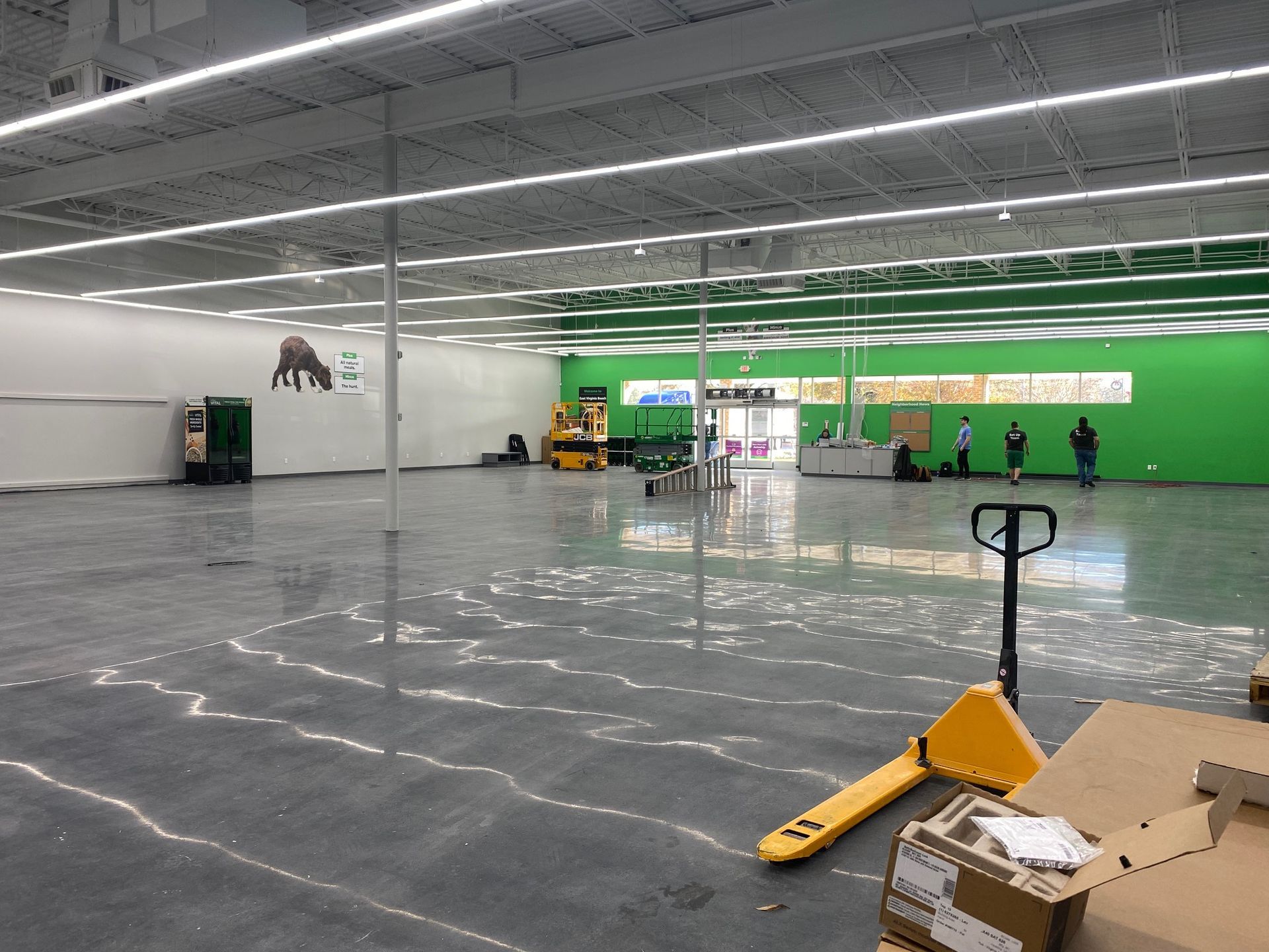 an empty store with a yellow hand truck in the middle