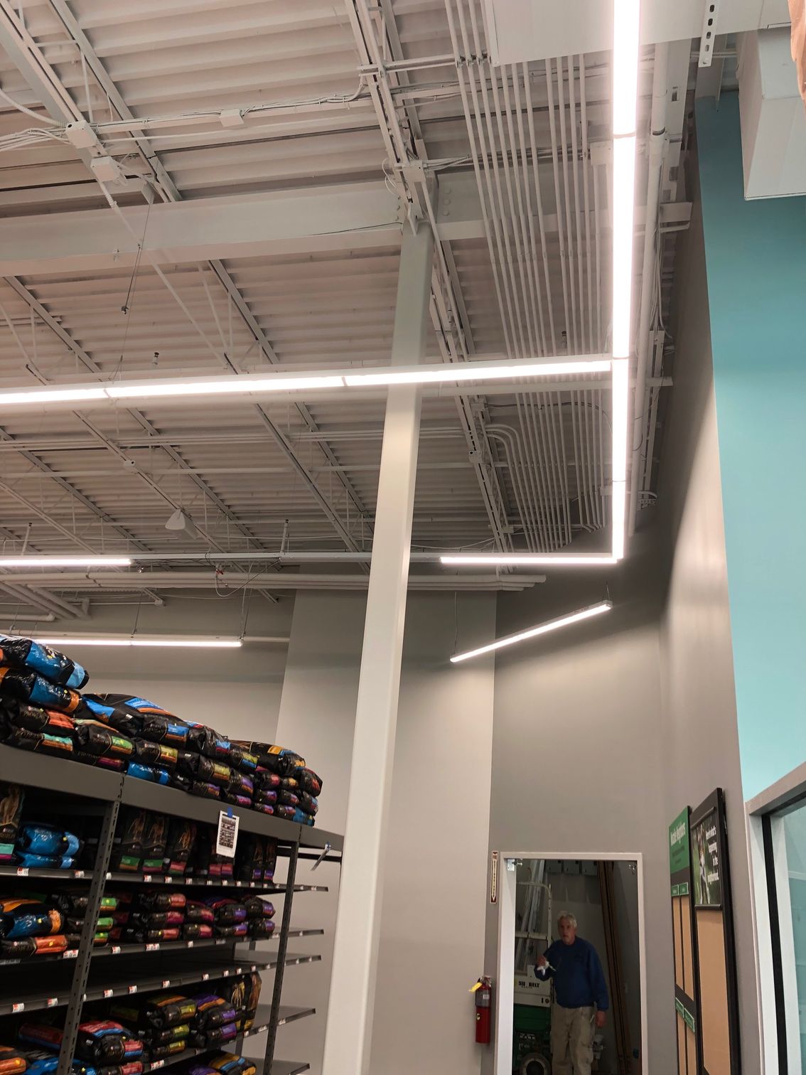 a man is standing in a store looking up at the ceiling