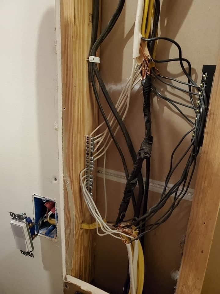 a bunch of wires are hanging from a wall in a room 