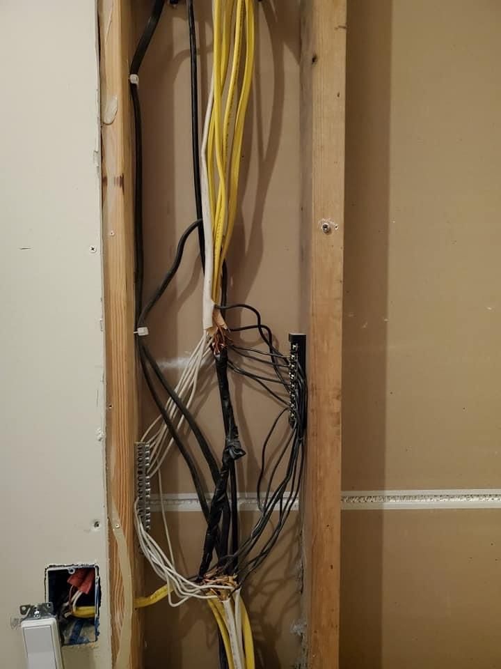 a bunch of wires are hanging from a wall in a wooden frame 