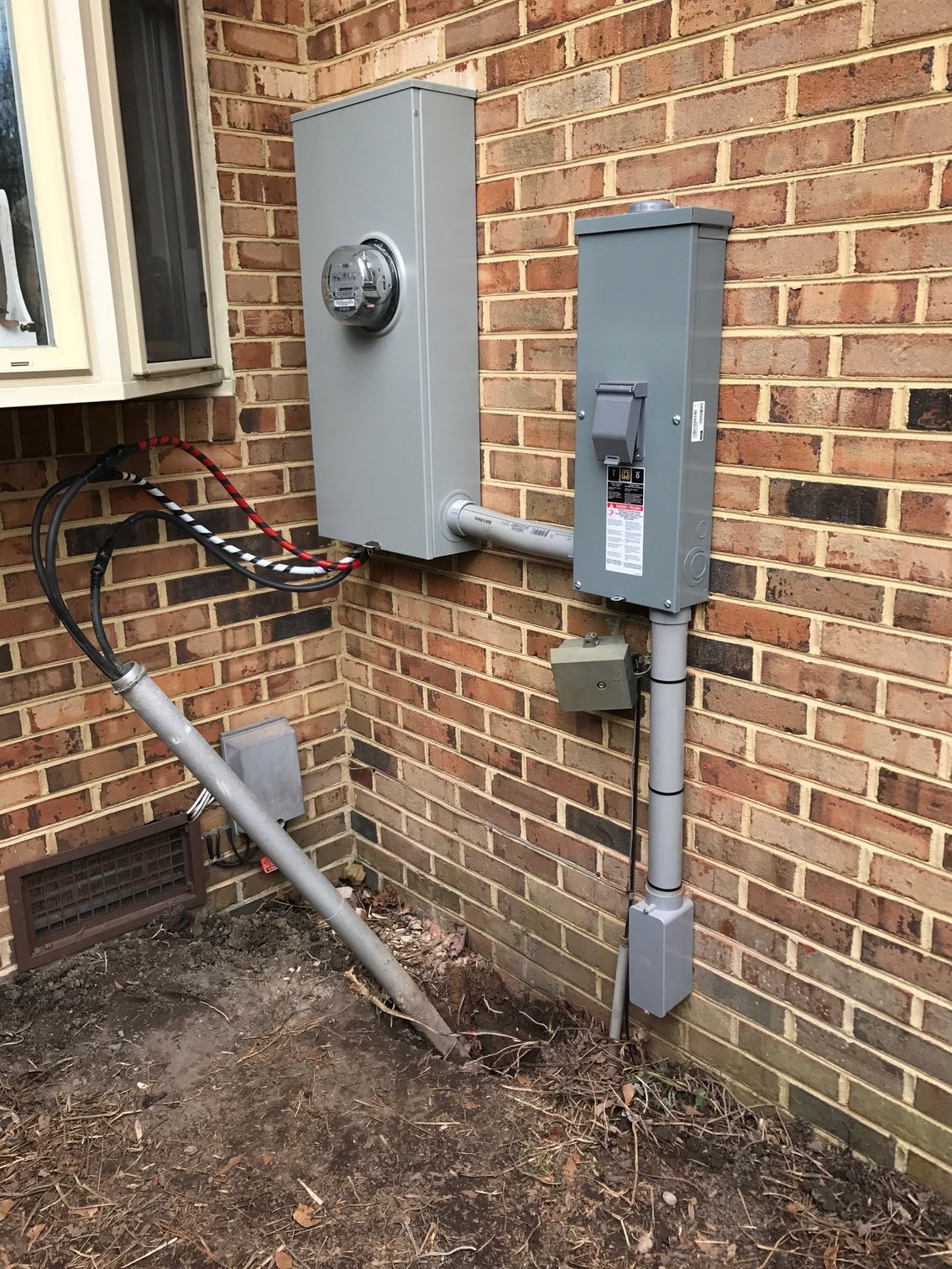 a brick wall with an electrical box attached to it 