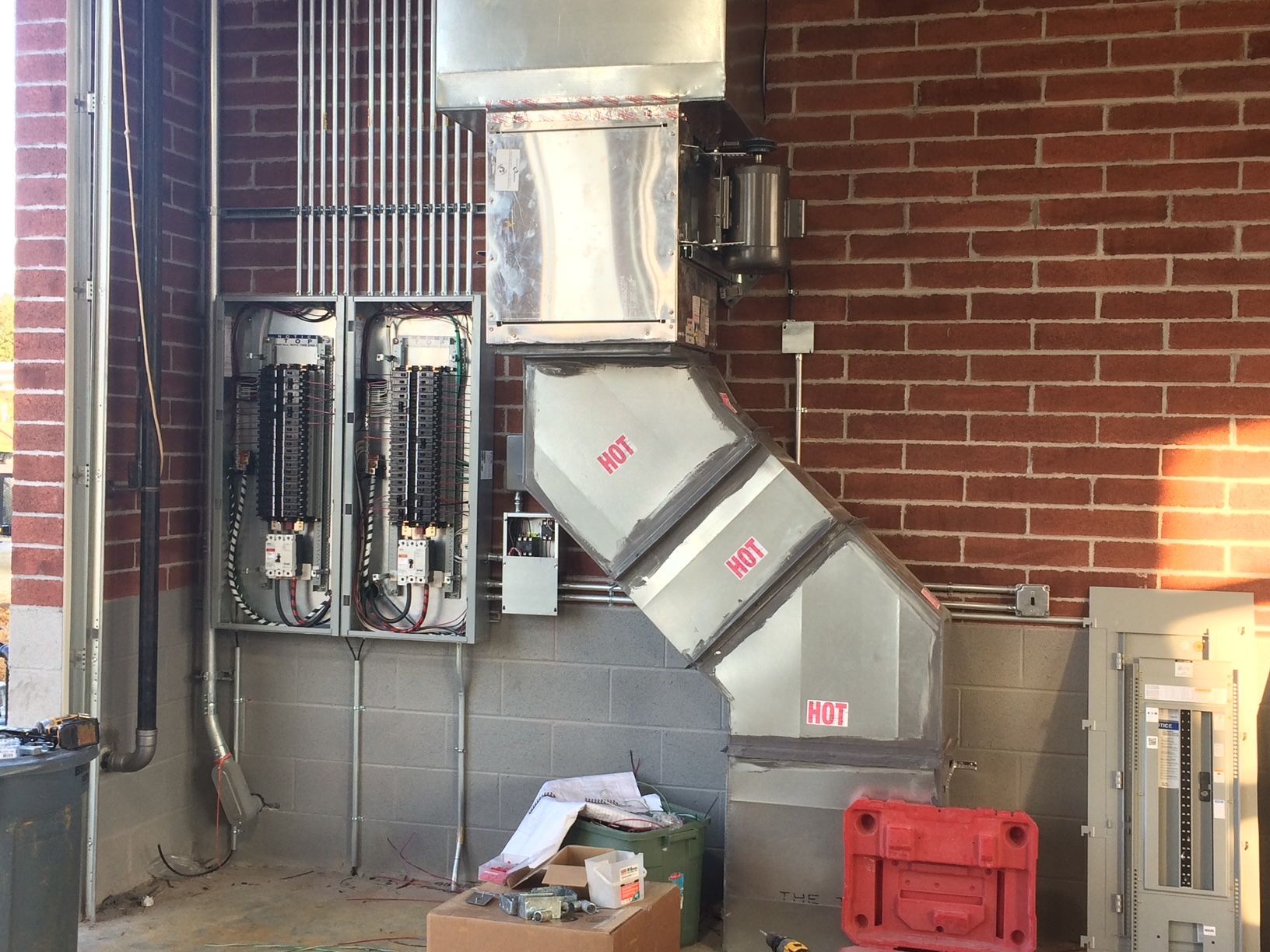 a brick wall with a stainless steel duct coming out of it 