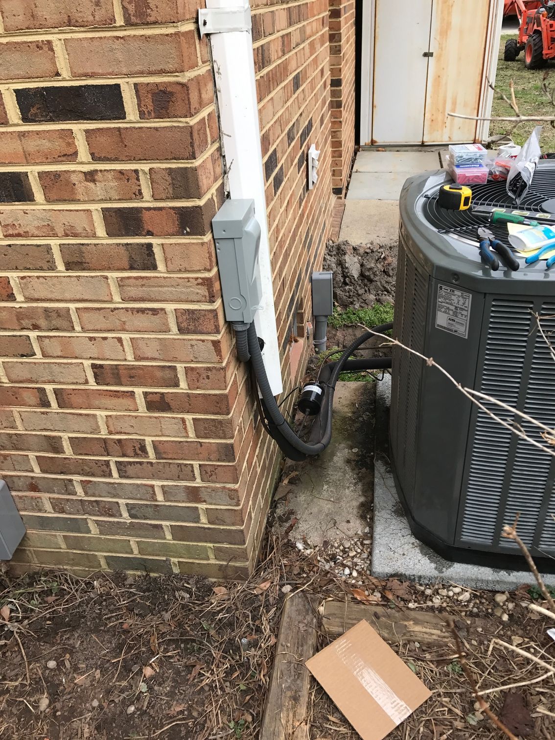 an air conditioner is sitting on the side of a brick building 
