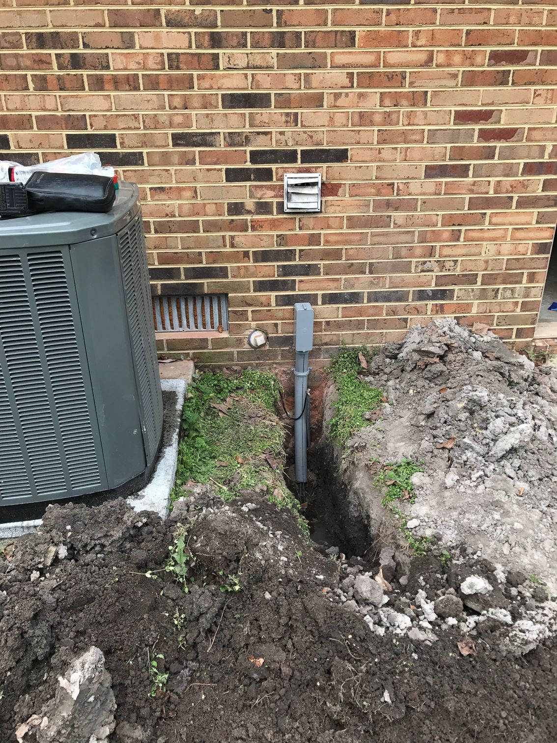 an air conditioner is being installed on the side of a brick building 