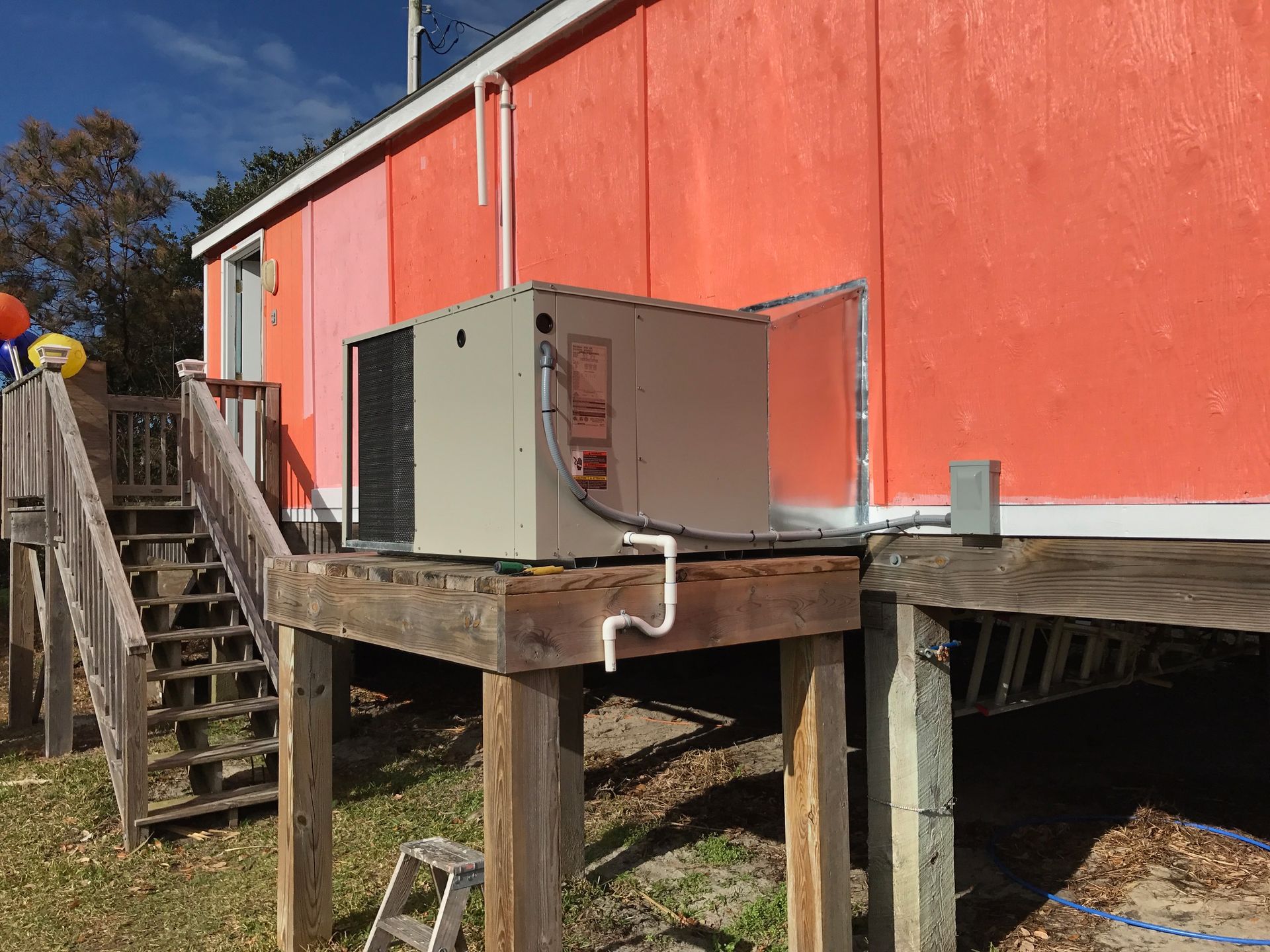 an air conditioner is sitting on the side of a red building 