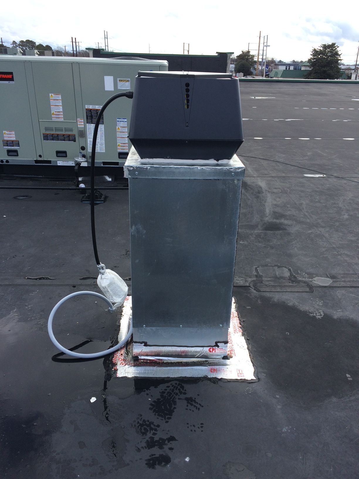 a chimney on top of a roof with a hose attached to it 