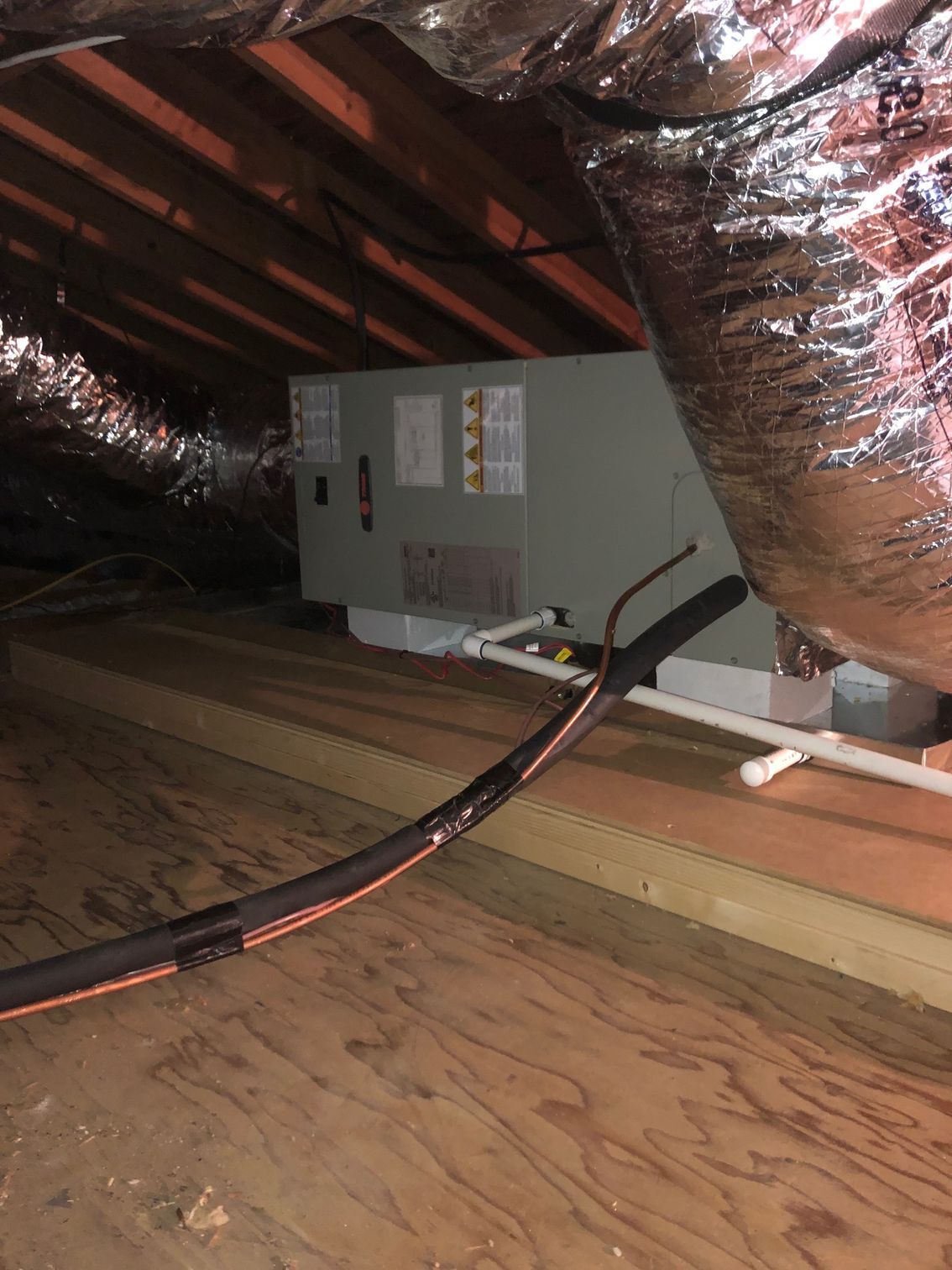 an air conditioner is sitting in the attic of a house