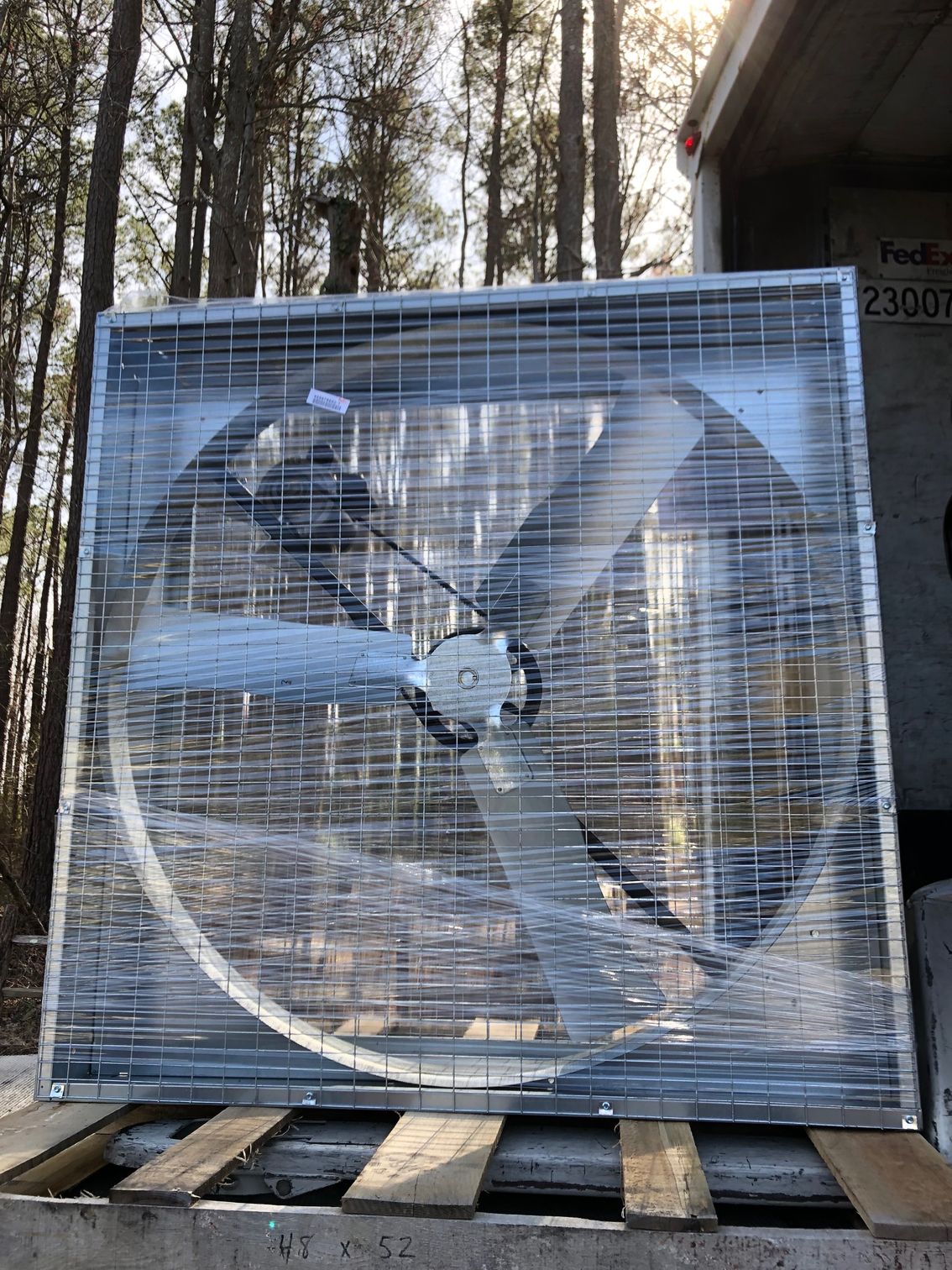 a large fan is sitting on top of a wooden pallet