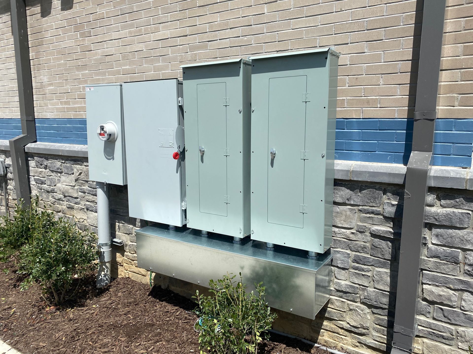 a large electrical box is sitting on the side of a brick building